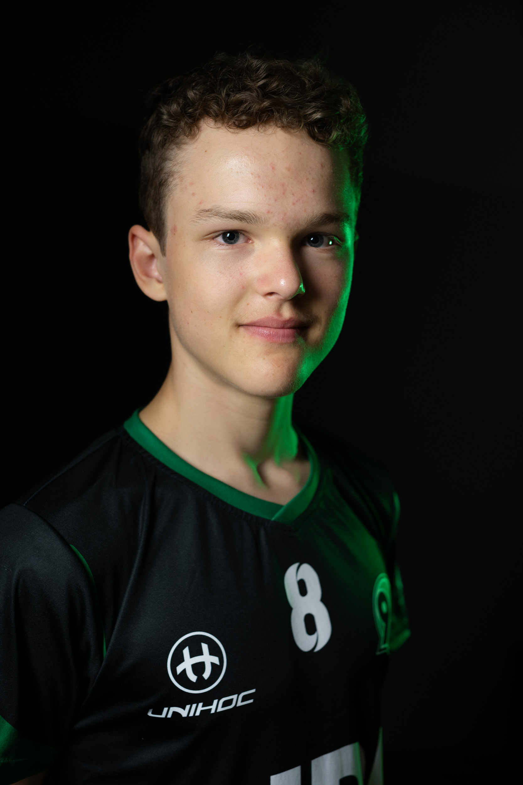 Ein Spieler lächelt im schwarzen Trikot in die Kamera.