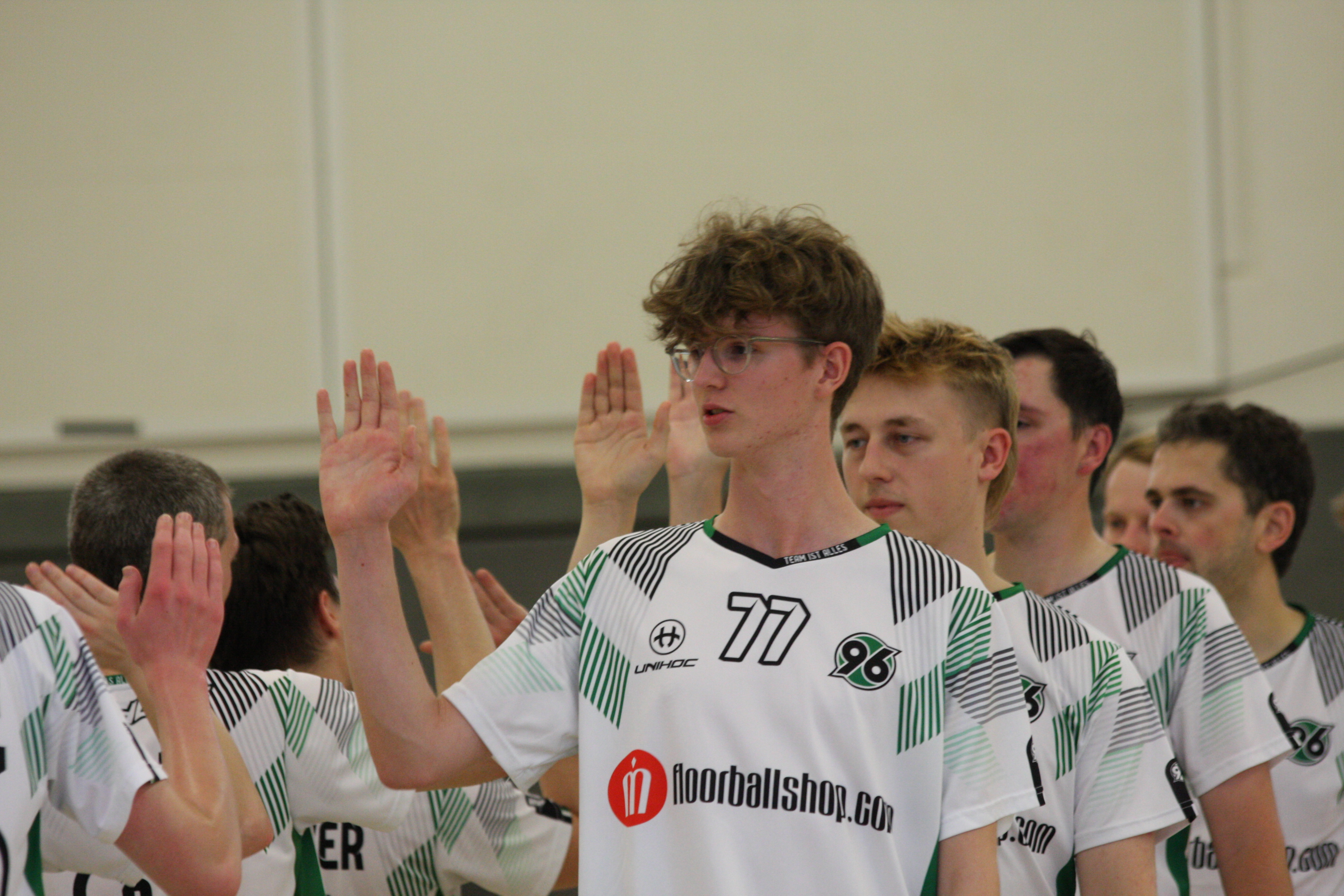 Ein Spieler klatscht mit anderen Spielern vor dem Spiel ab. 