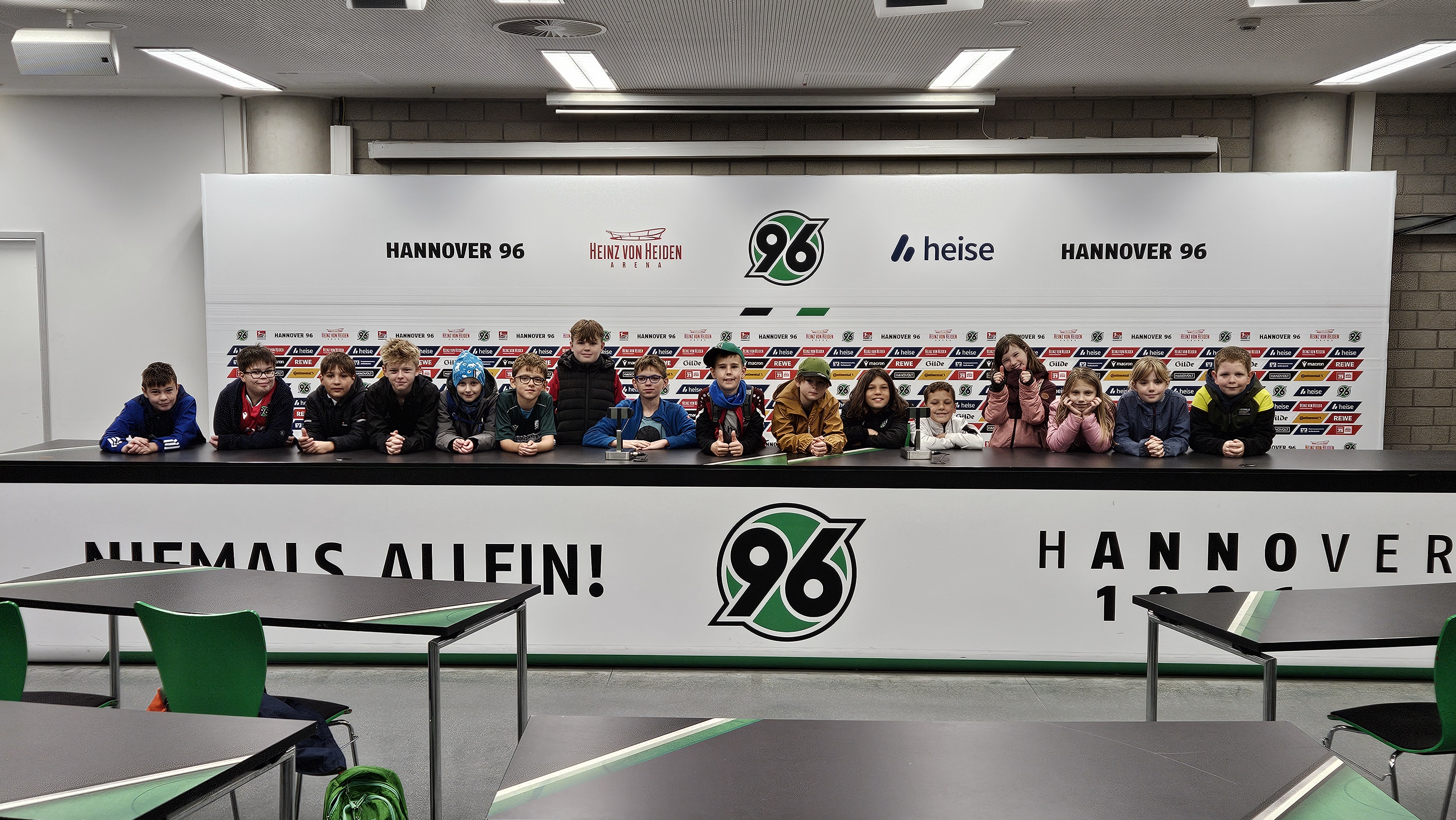Die Kinder stehen auf der Tribüne im Presseraum.