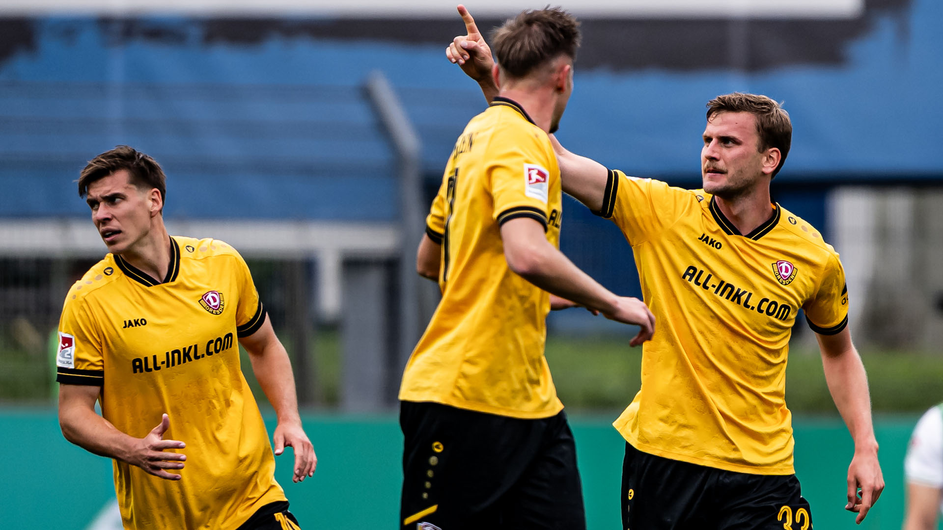 Drei Dresdener Fußballspieler während eines Spiels.
