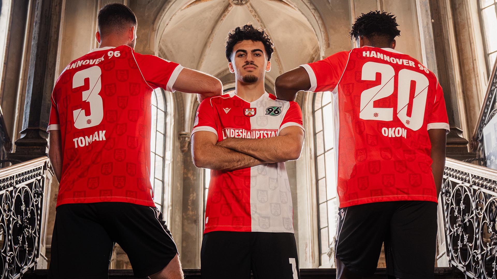 Die drei 96-Spieler Boris Tomiak, Husseyn Chakroun und Ime Okon posieren zusammen in den rot-weißen Sondertrikots.