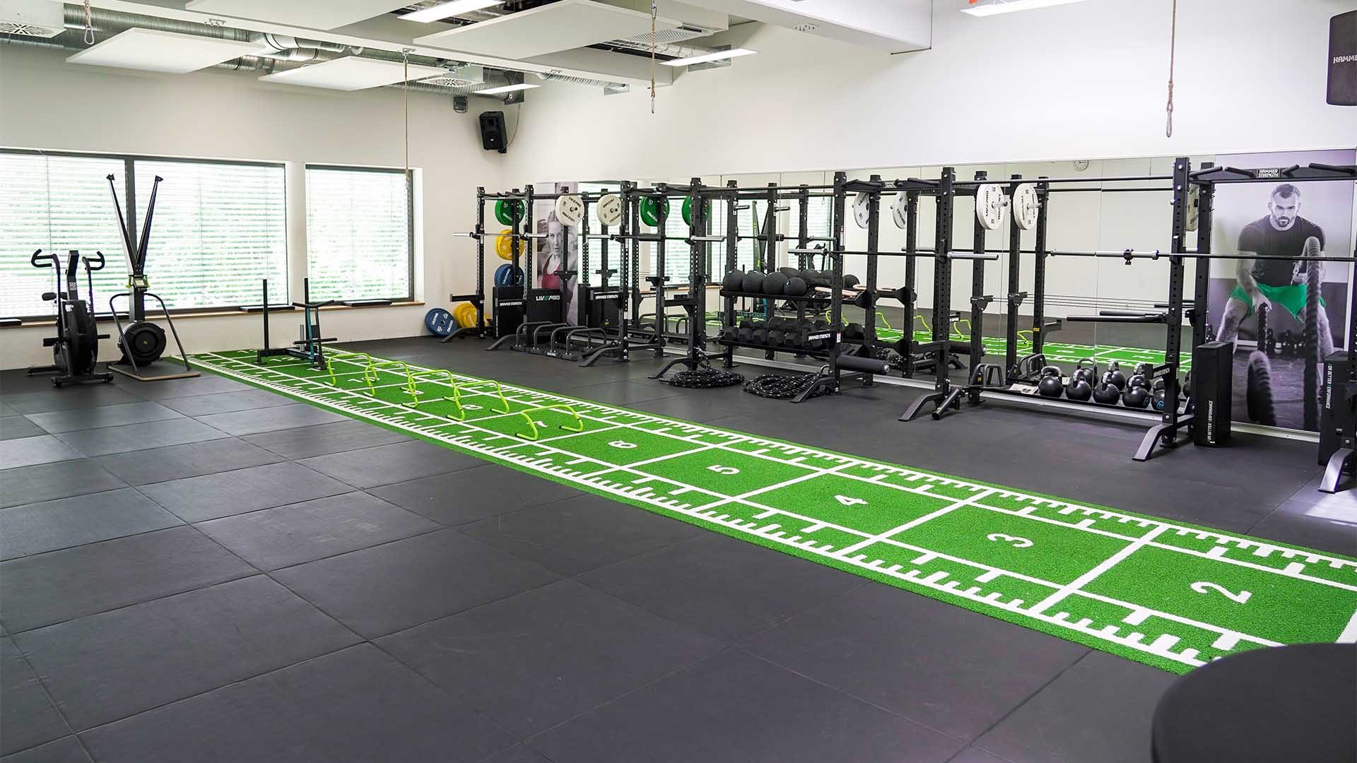 Ein Fitnessraum mit Matten und Sportgeräten.