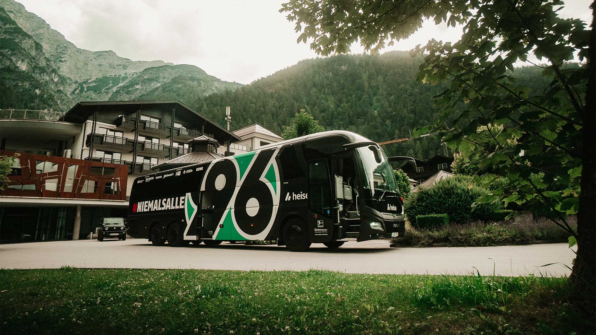 Der Hannover-96-Mannschaftsbus steht vor dem Hotel, im Hintergrund sind Berge zu sehen.