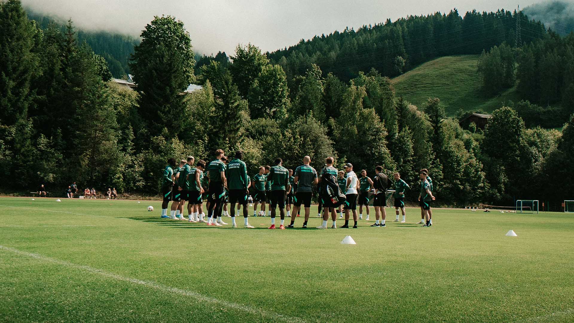 Das 96-Team steht auf dem Platz in Saalfelden, im Hintergrund sind Berge.