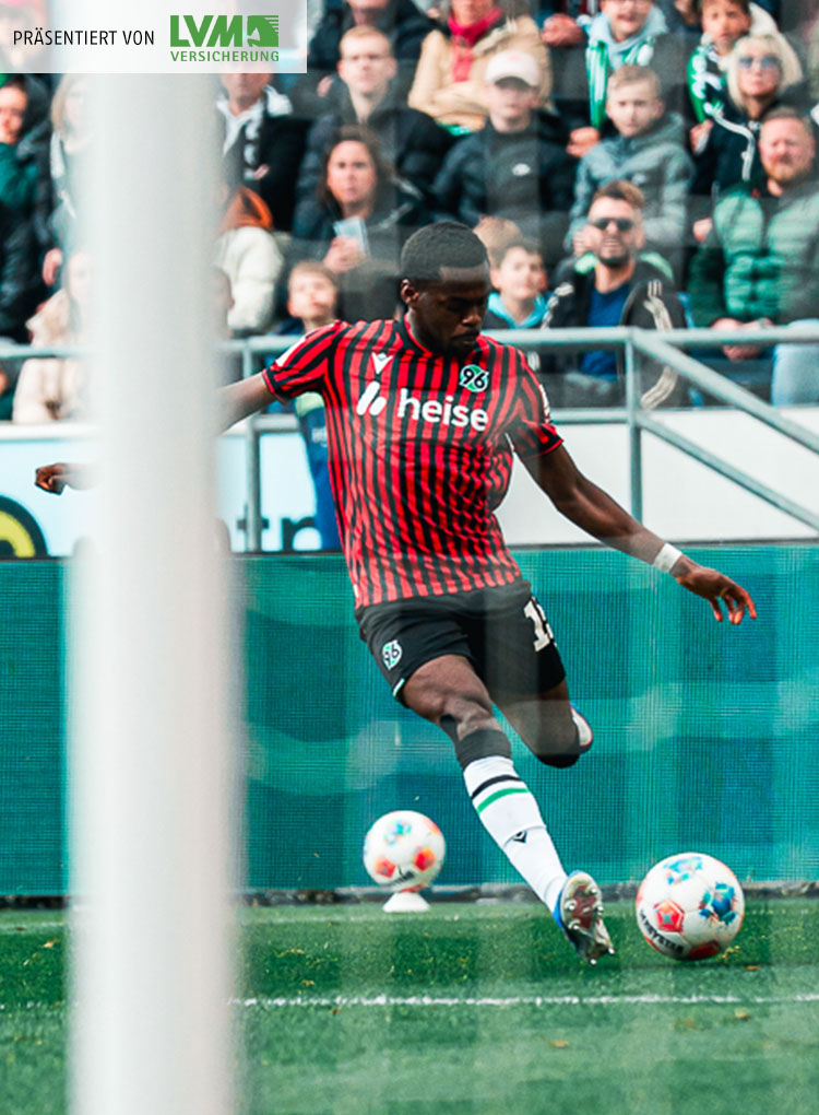 Noel Aseko am Ball, im Vordergrund ist unscharf das Tornetz zu sehen.