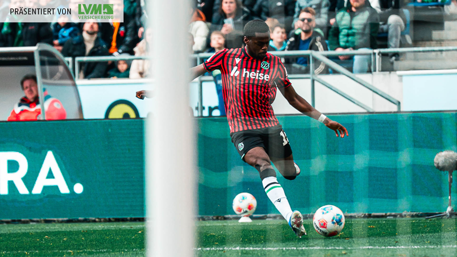 Noel Aseko am Ball, im Vordergrund ist unscharf das Tornetz zu sehen.