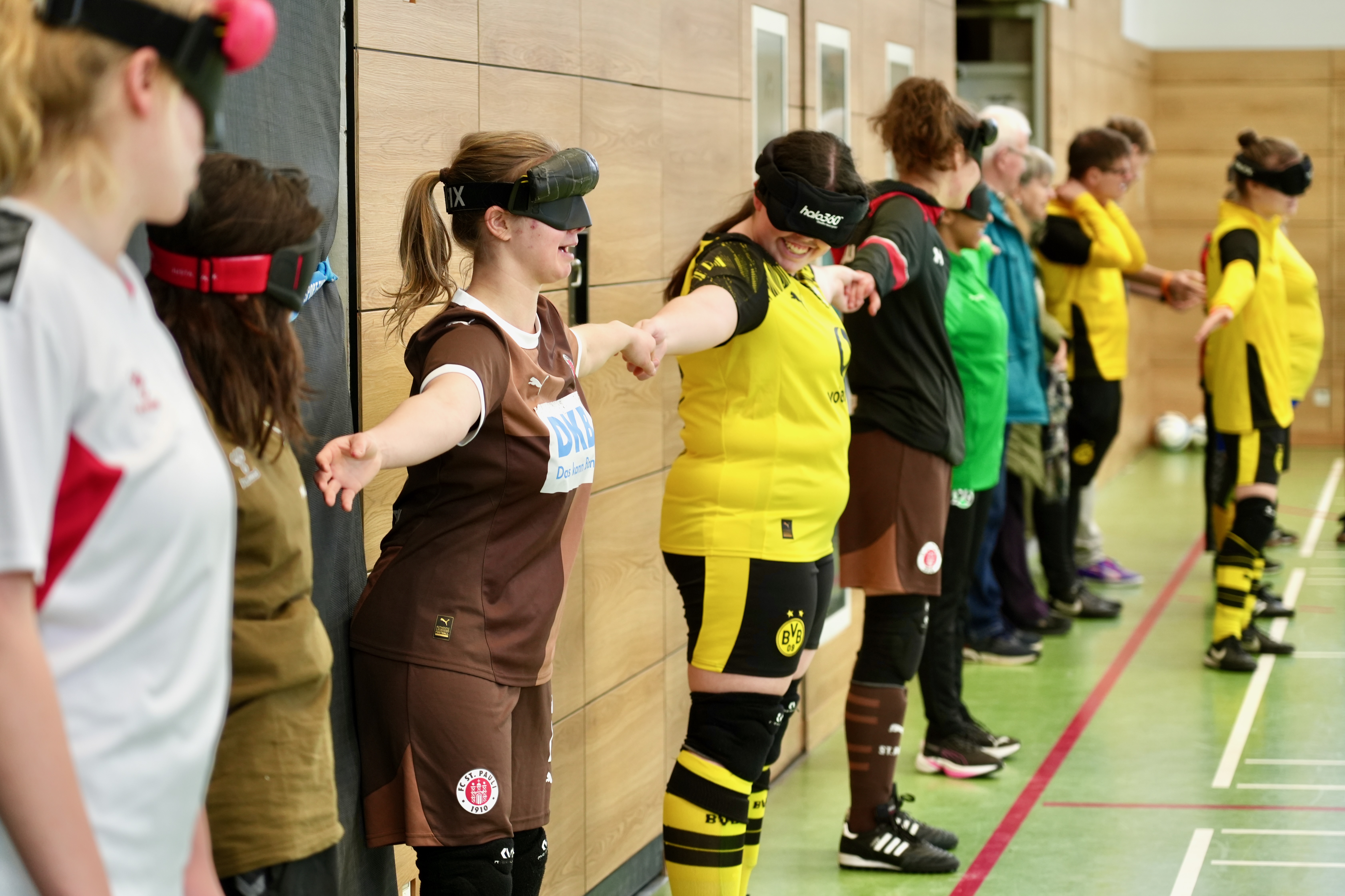 Die Teilnehmerinnen stehen mit Dunkelbrillen auf einer Linie.
