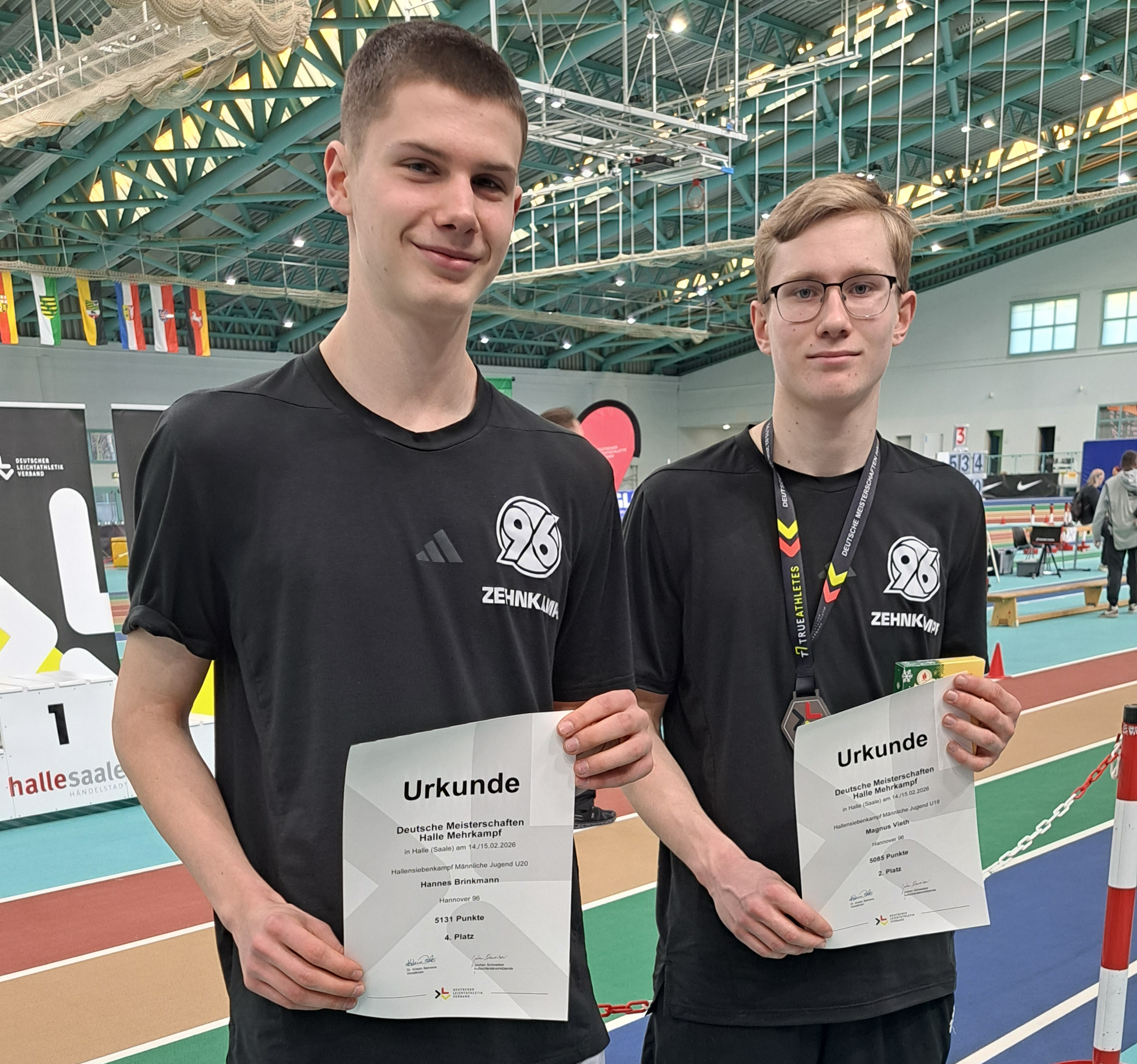 Hannes Brinkmann und Magnus Vieth halten ihre Urkunde in die Luft.