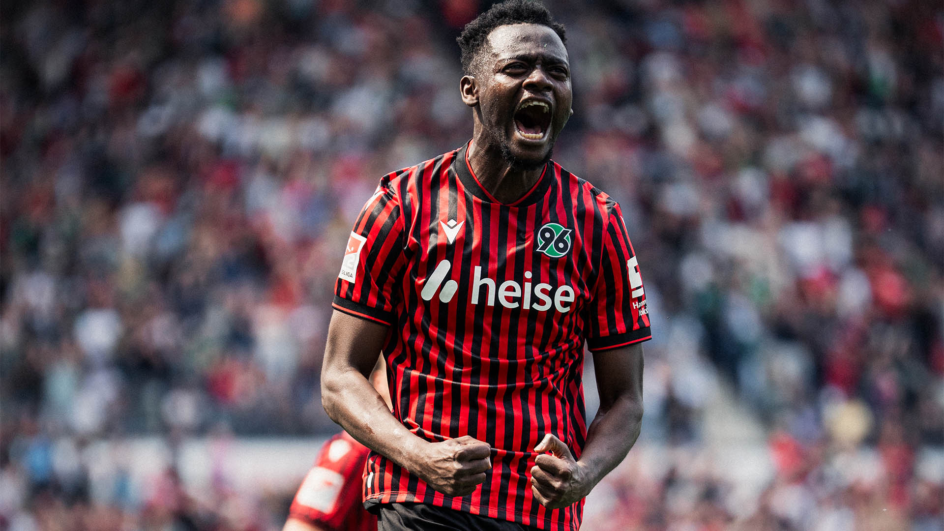 Mustapha Bundu jubelt im Heimtrikot mit geballten Fäusten.