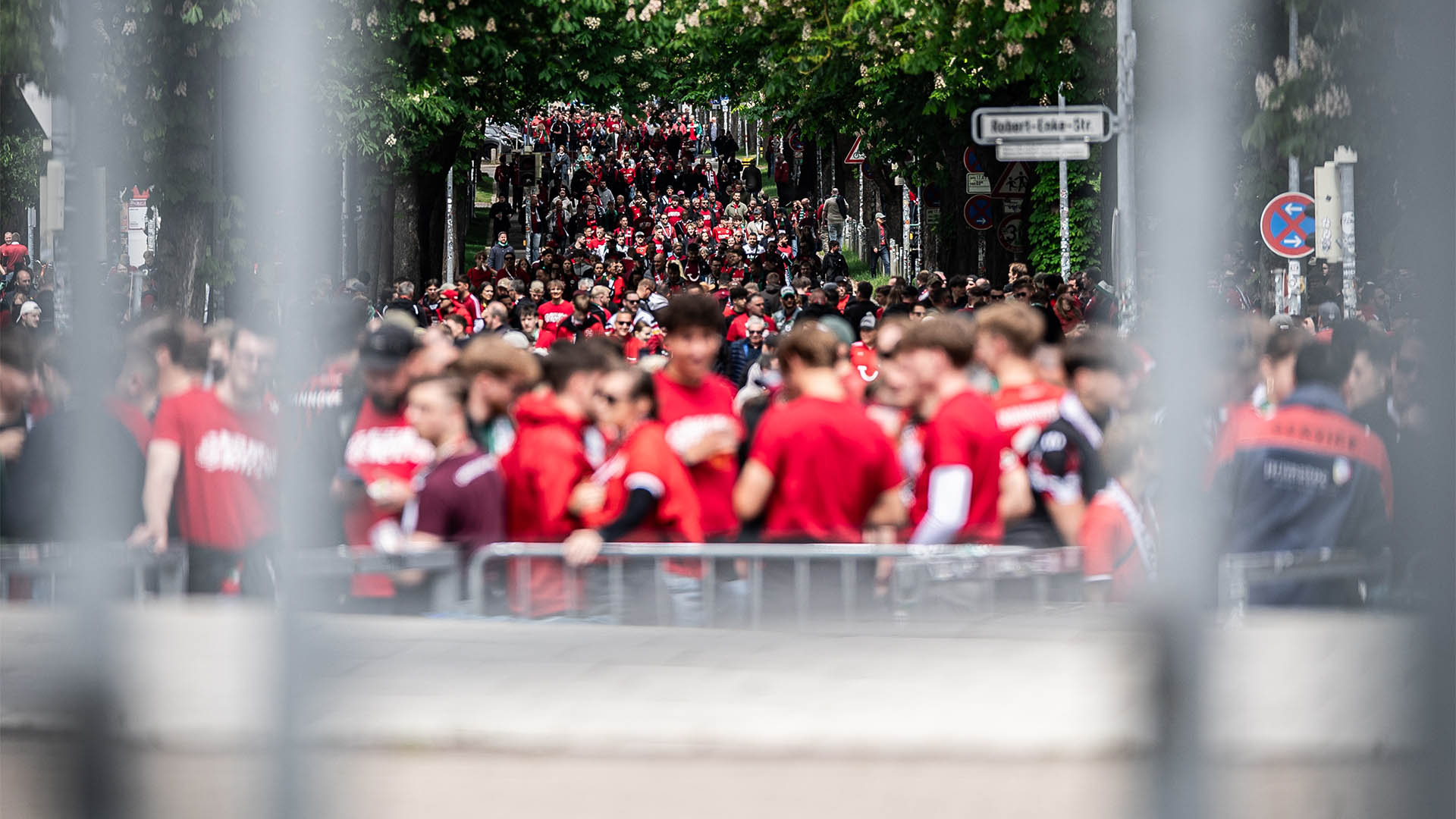 Zahlreiche in Rot gekleidete 96-Fans strömen in Richtung Stadion.