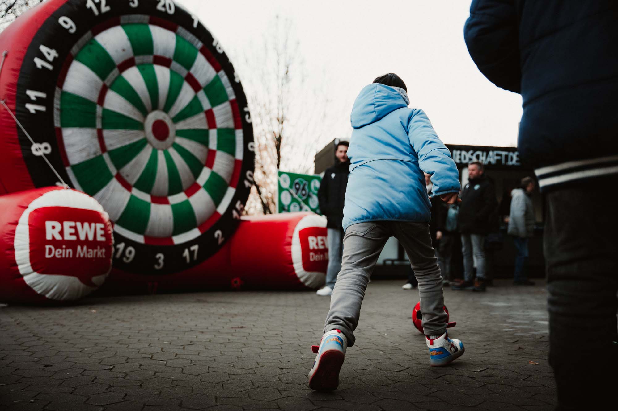 Ein Kind schießt auf eine Torwand.