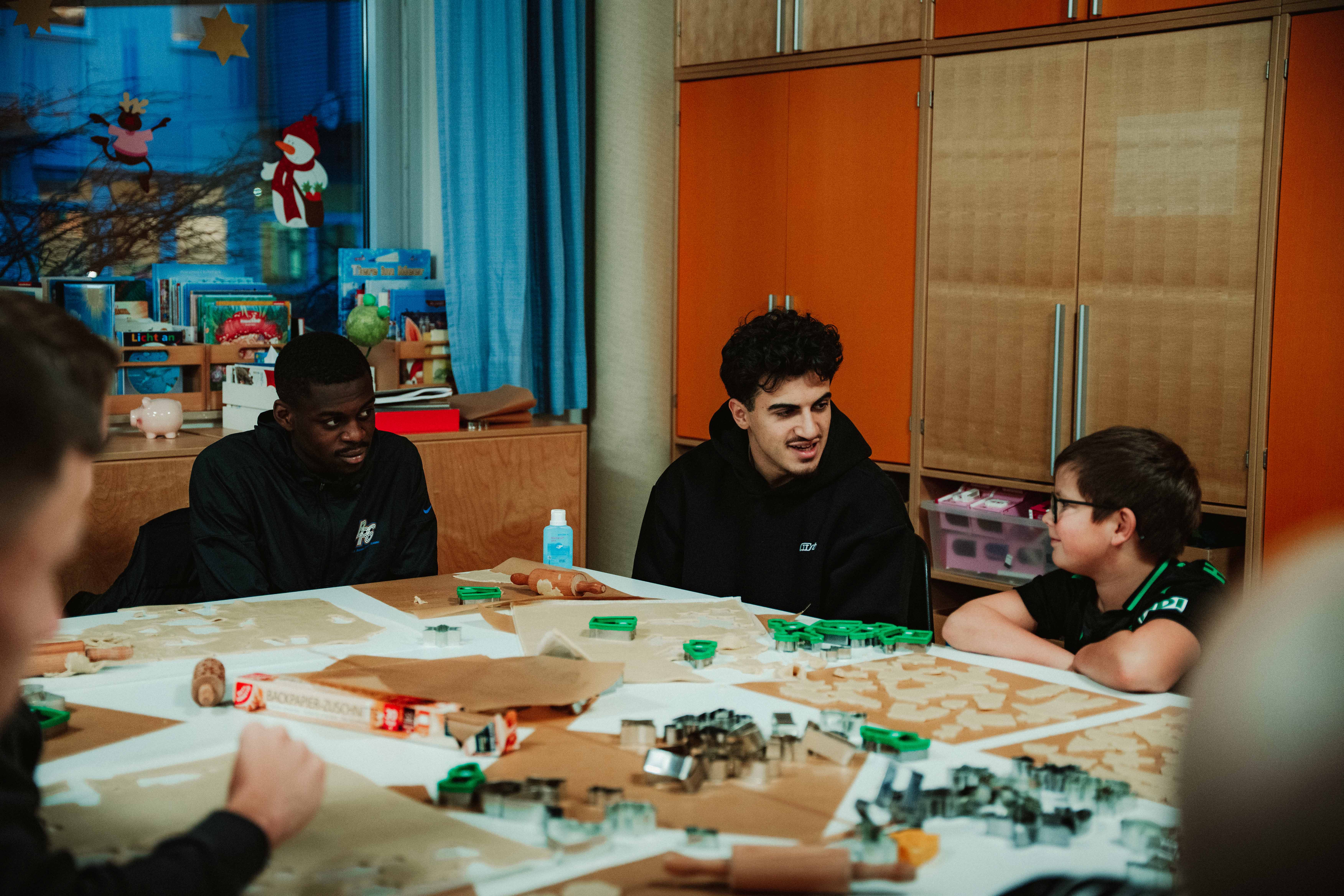 Die Profis backen Kekse mit den Kindern.