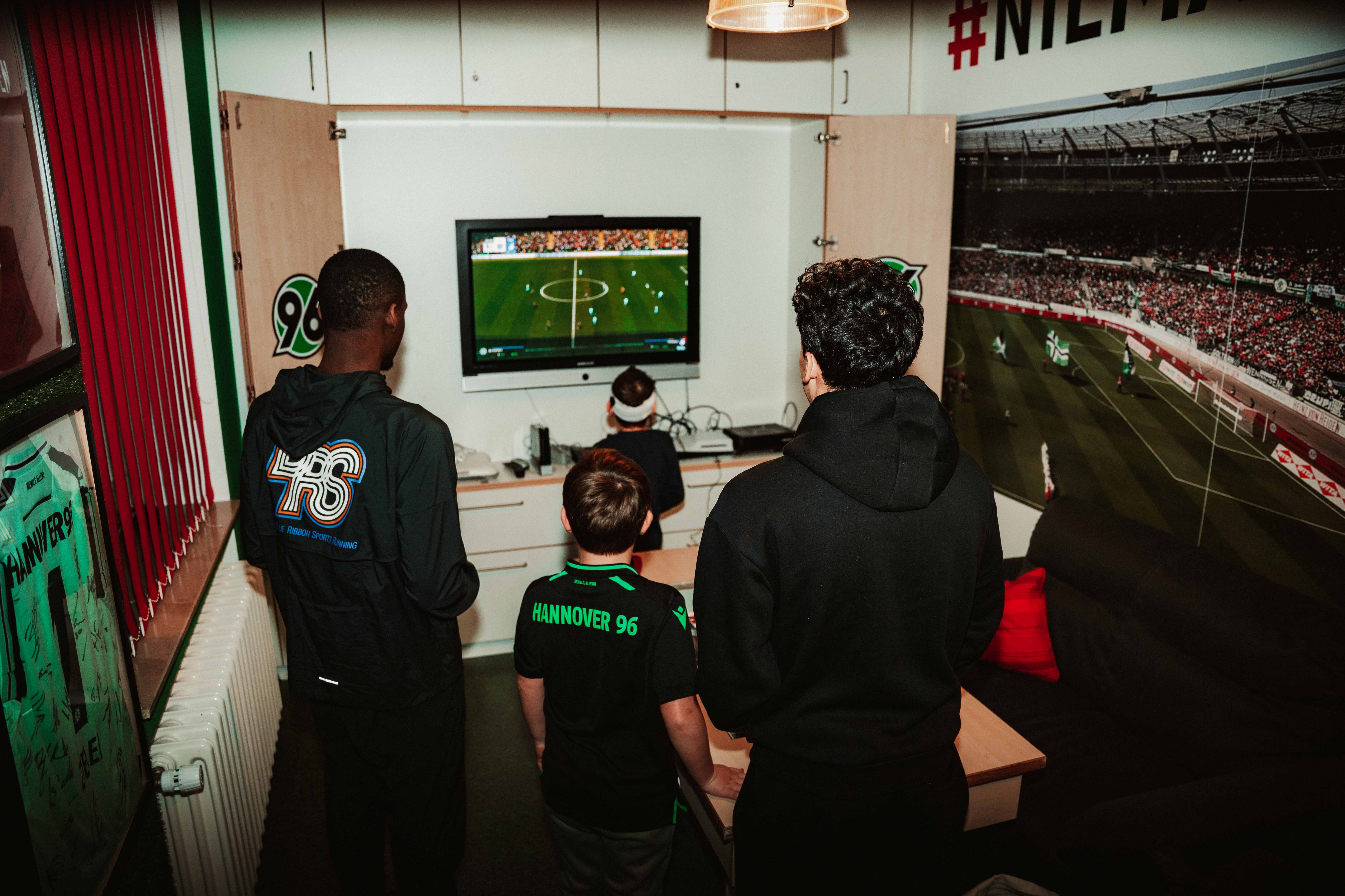 Die Profis spielen EA FC mit den Kindern.