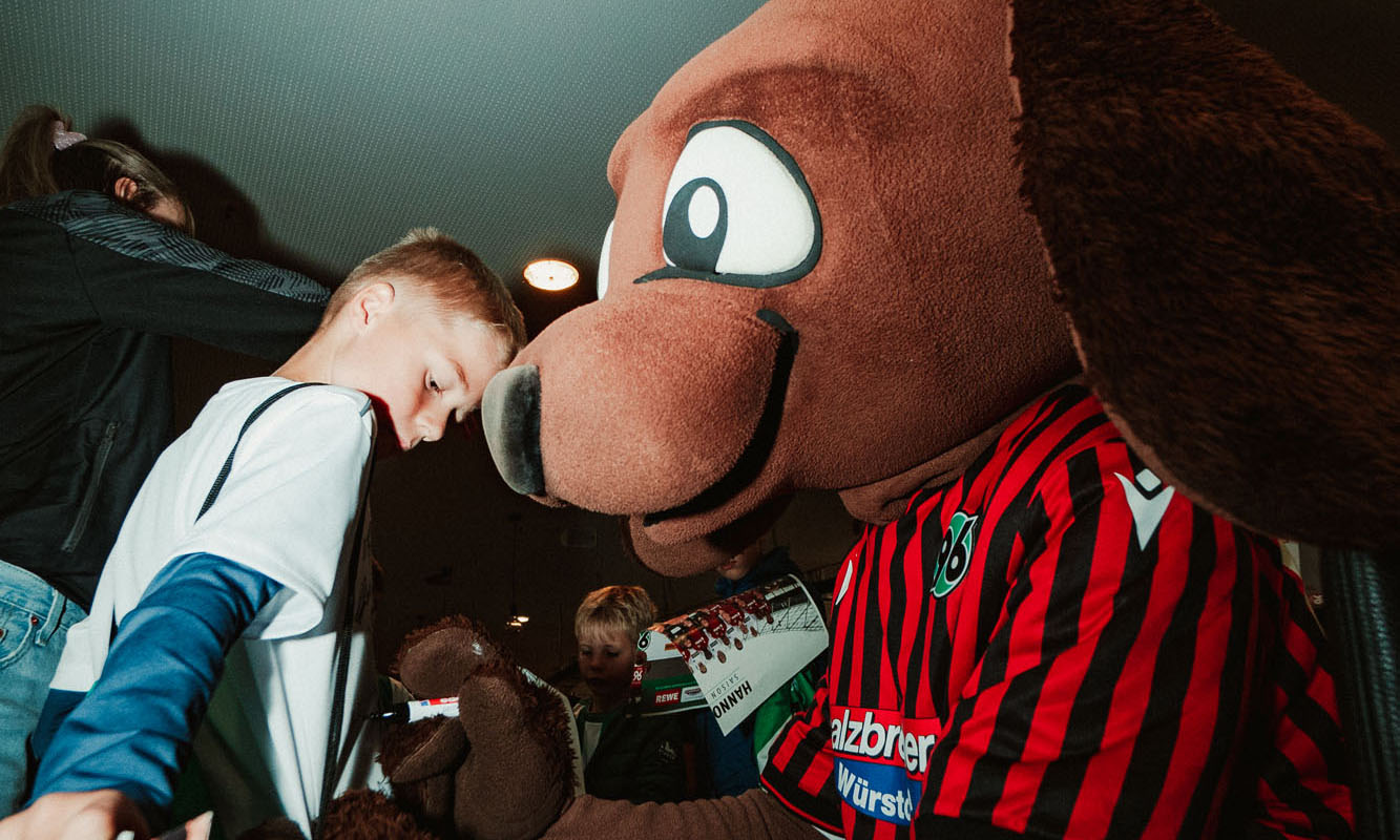 EDDI unterschreibt auf dem Trikot eines kleinen Fans.