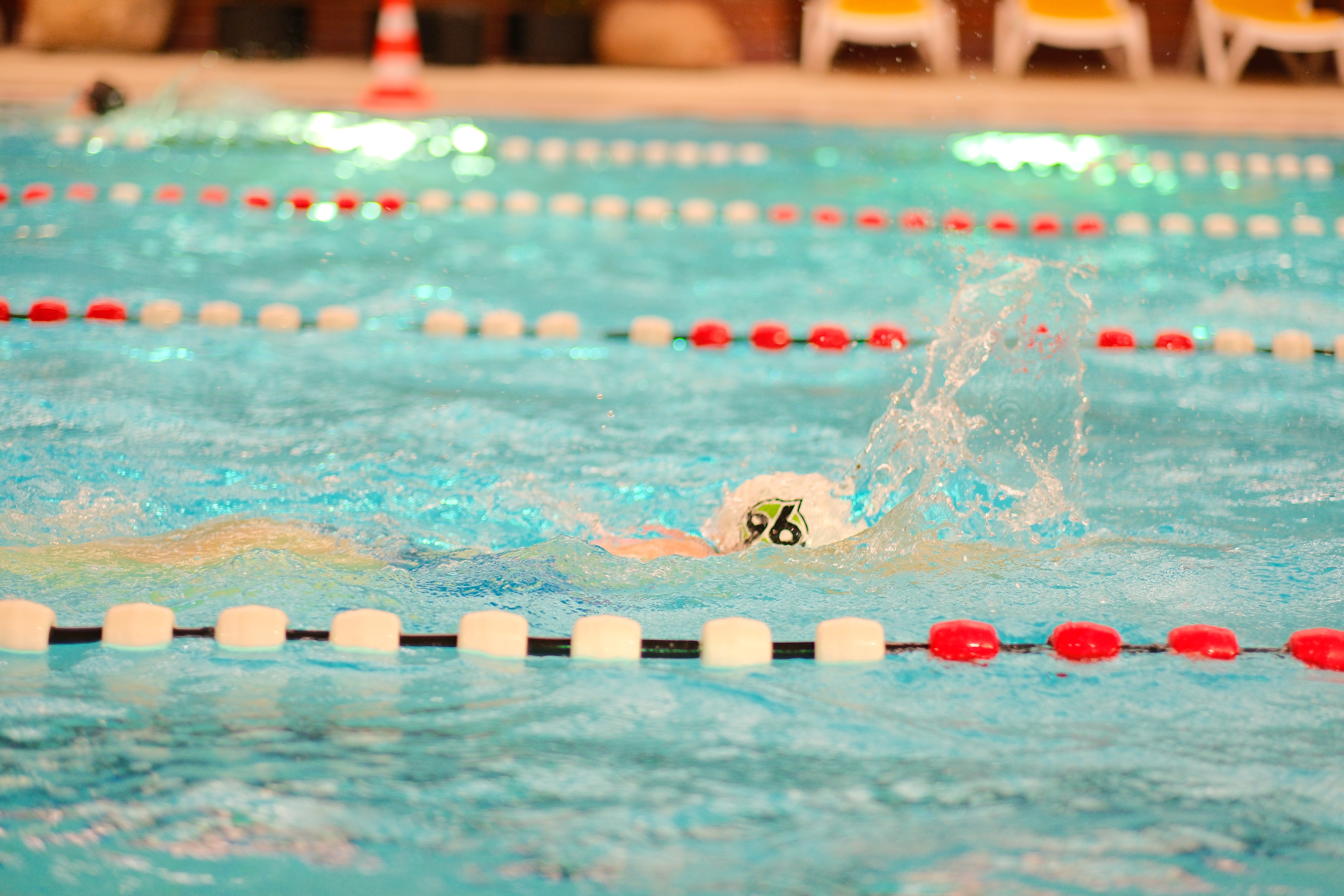 Zu sehen ist ein Schwimmer mit einer Hannover 96- Badekappe