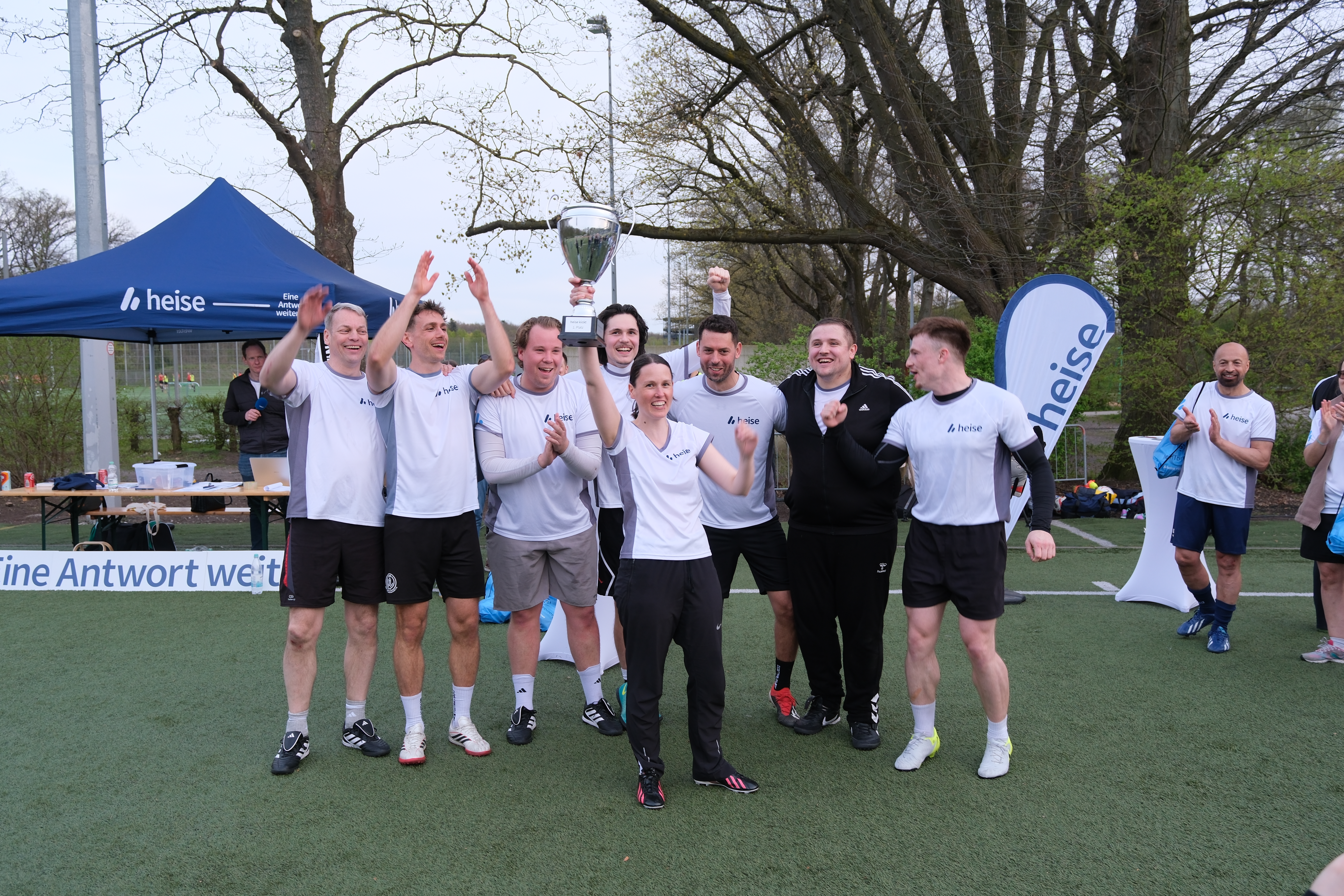 Das Team "Rudelbildung" streckt erfreut den Pokal in den Himmel.