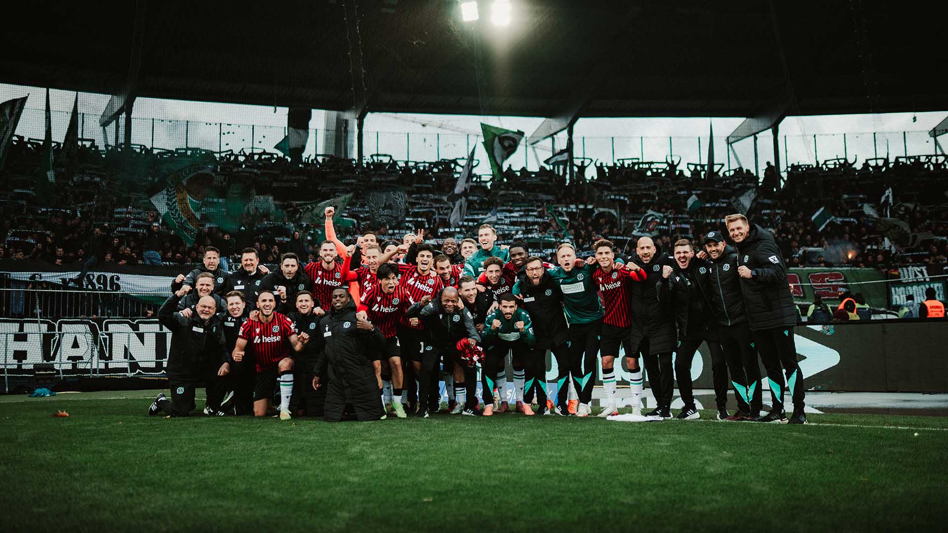 Das komplette 96-Team posiert jubelnd mit den 96-Fans. 