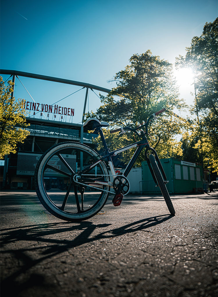 Ein Fahrrad steht in der Sonne vor dem Norden der Heinz von Heiden Arena.