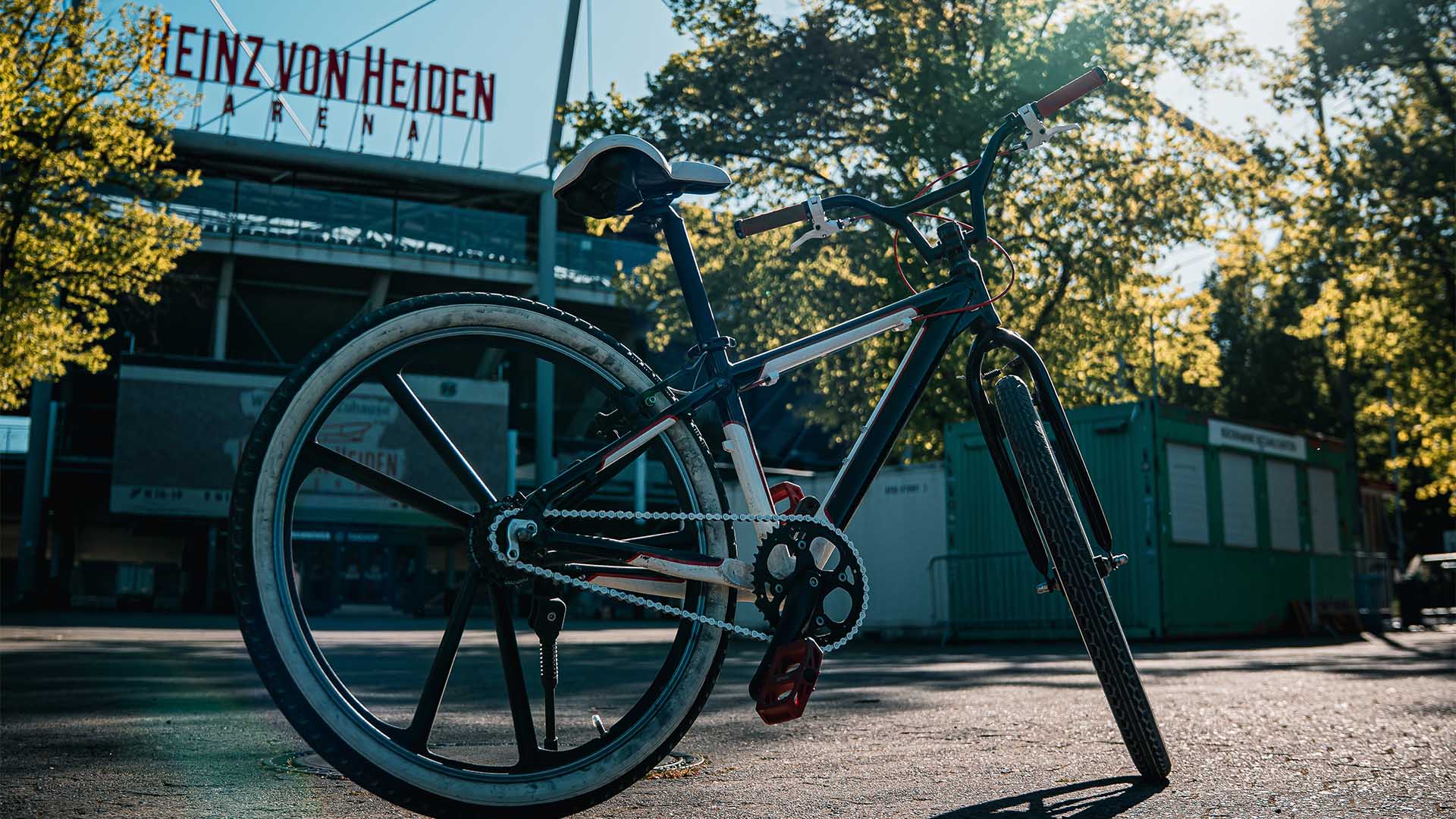 Ein Fahrrad steht in der Sonne vor dem Norden der Heinz von Heiden Arena.