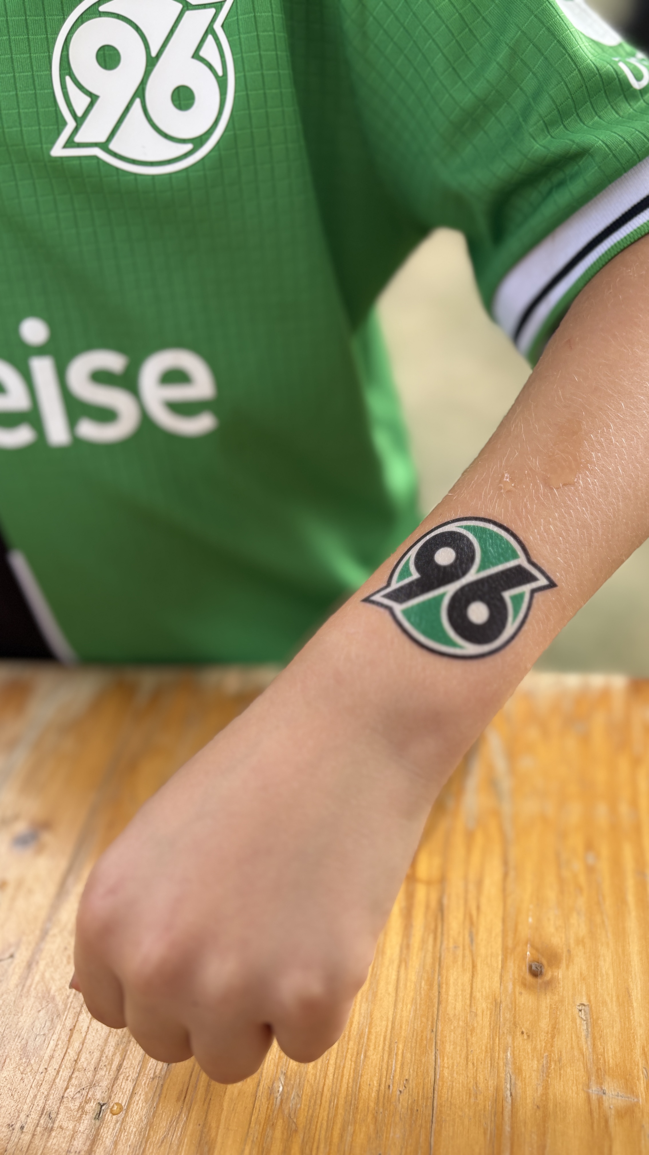 Person hält Arm mit 96-Klebetattoo in die Kamera.