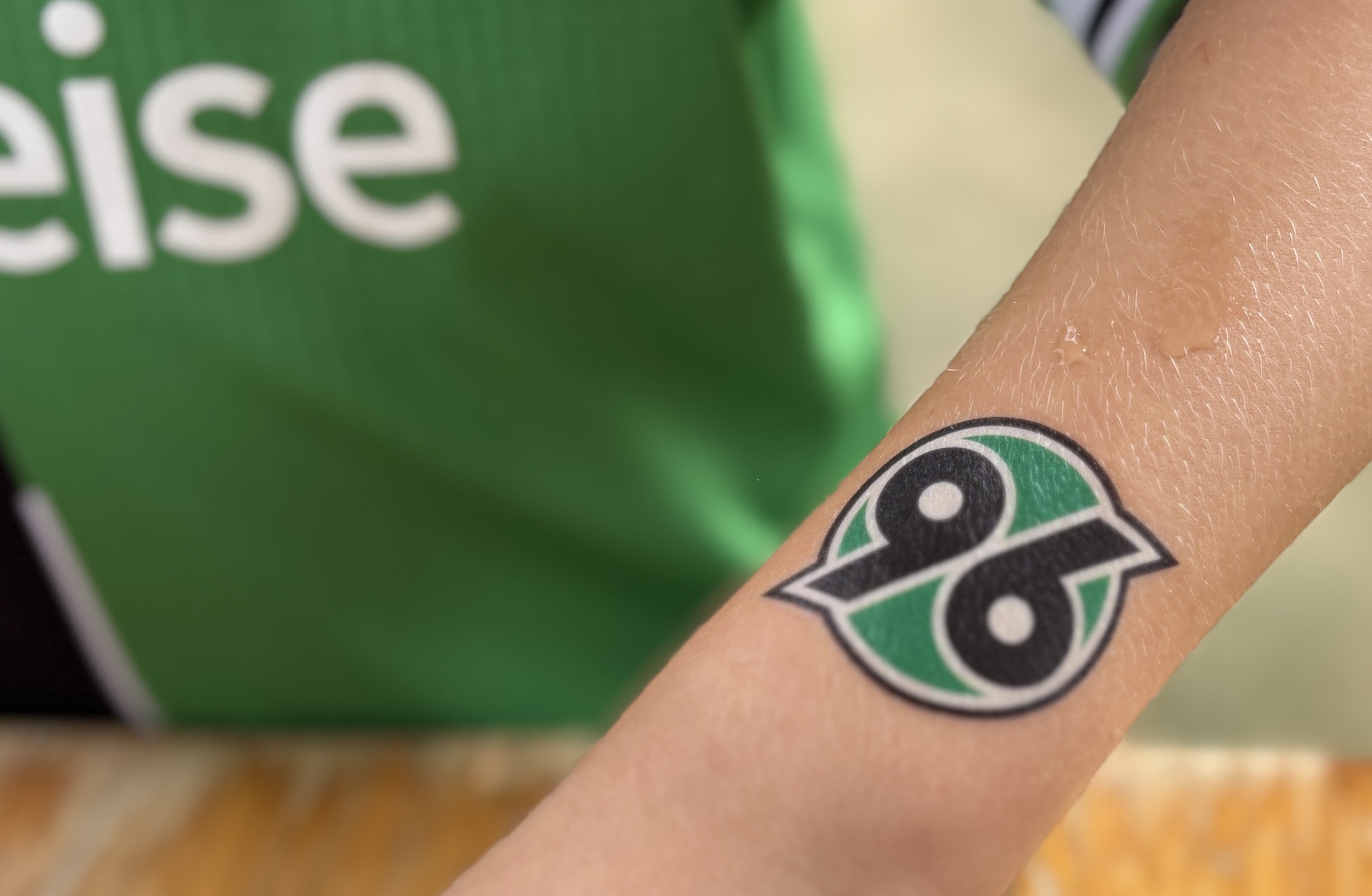 Person hält Arm mit 96-Klebetattoo in die Kamera.