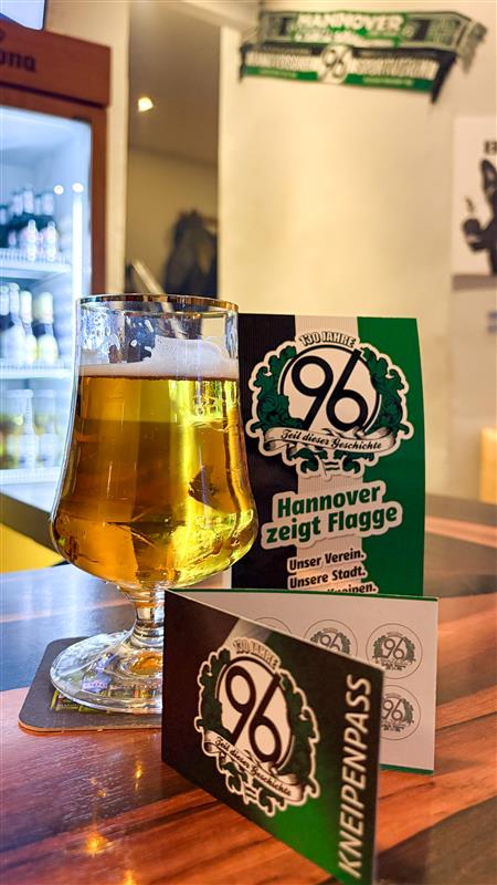 inks im Bild sieht man ein großes Glas Bier und rechts daneben befindet sich der 96 Kneipenpass.