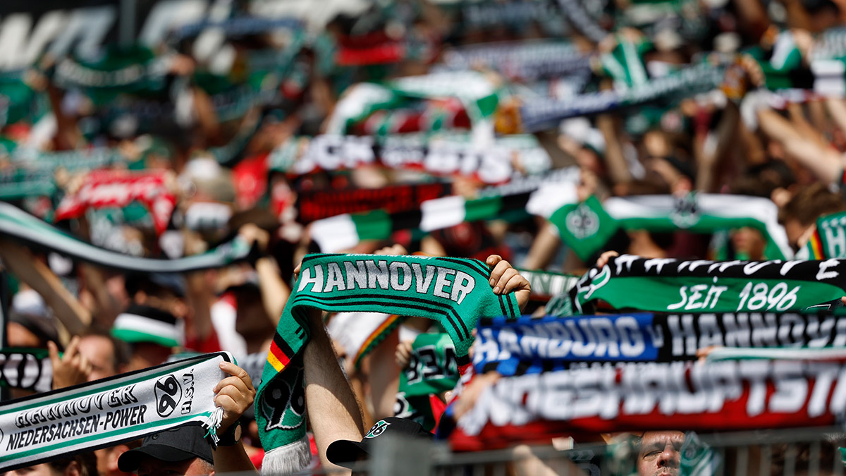 96-Fans halten Schals in die Höhe.