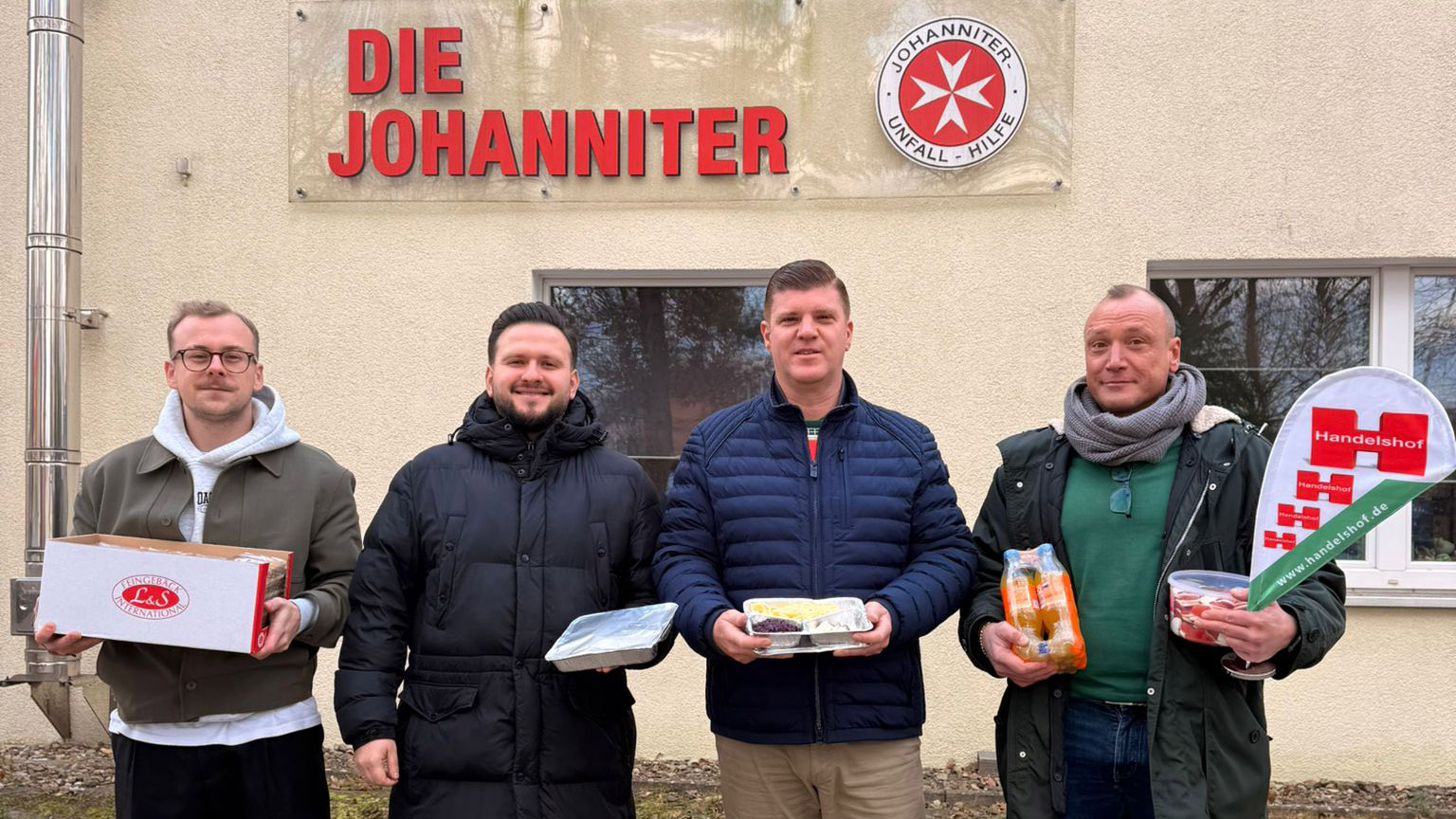 Frederick Schäfer (Rodizio Baumhaus) (von links), Juri Sladkov (Leiter Nachhaltigkeit und CSR bei Hannover 96) sowie Tobias Hampel und Arne Erbloweit (Handelshof) vor der Johanniter Unfallhilfe.