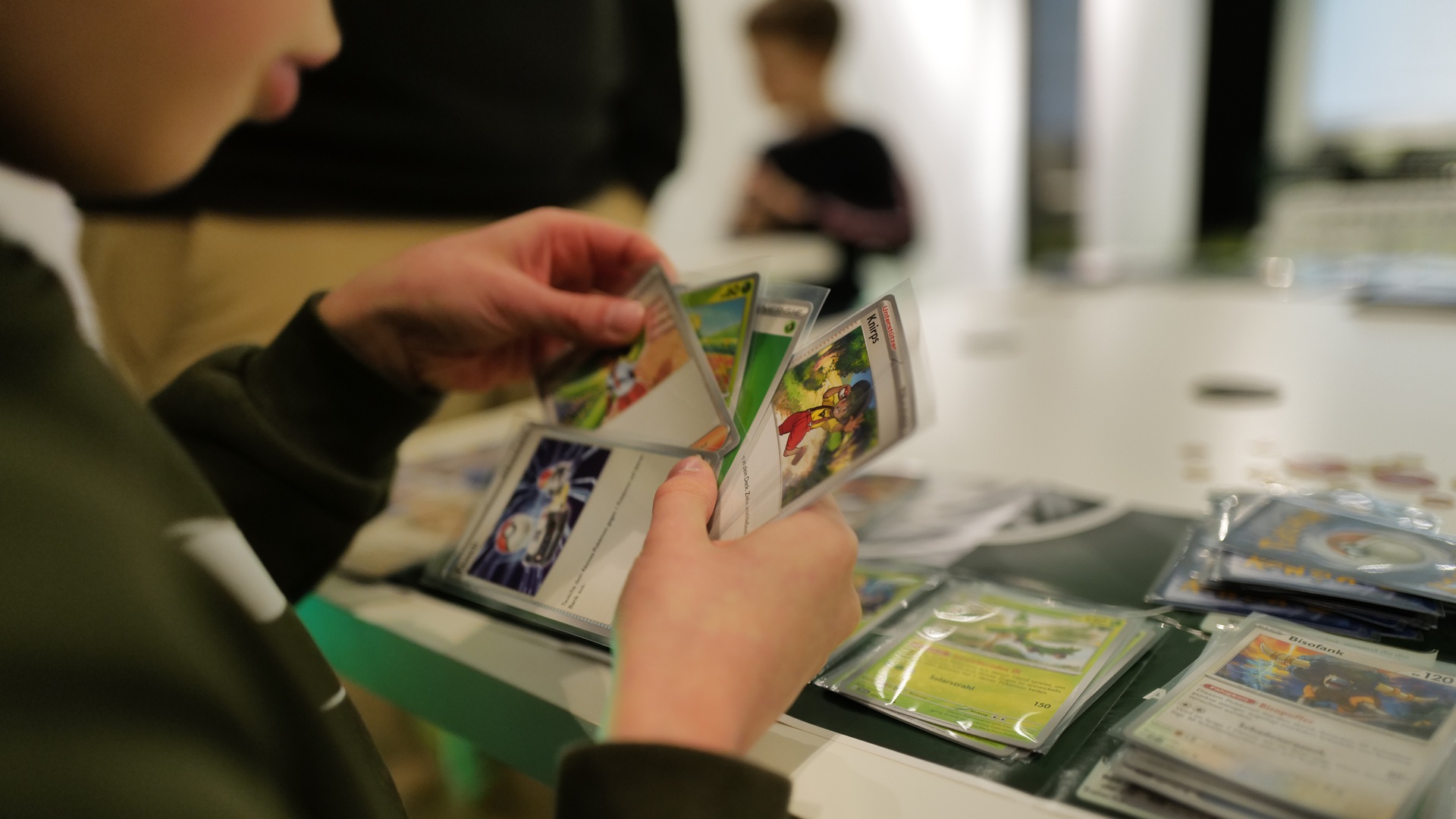 Junge hält Pokémon-Sammelkarten in seinen Händen