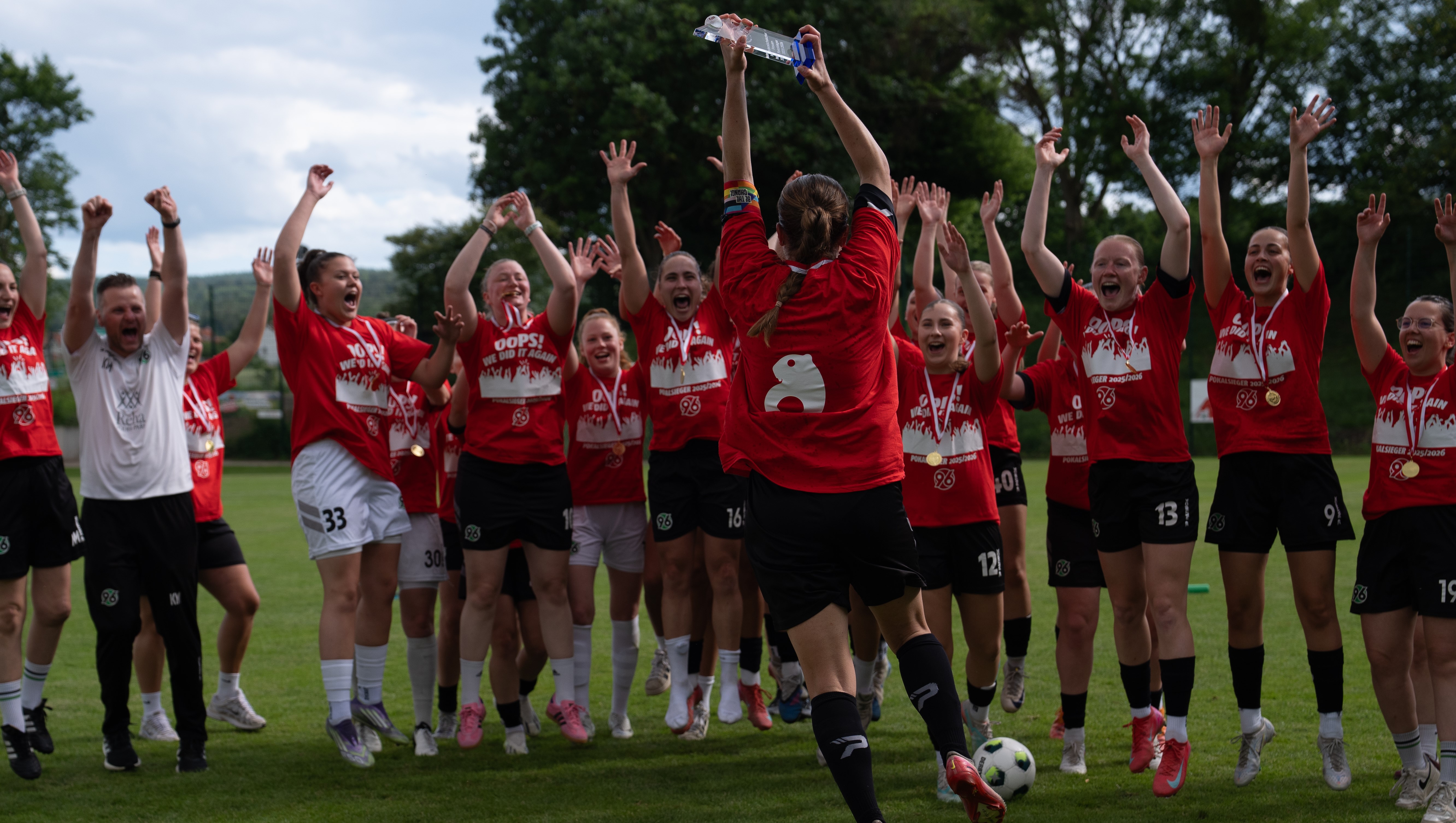 Die Spielerinne feiern mit dem gewonnenen Pokal.