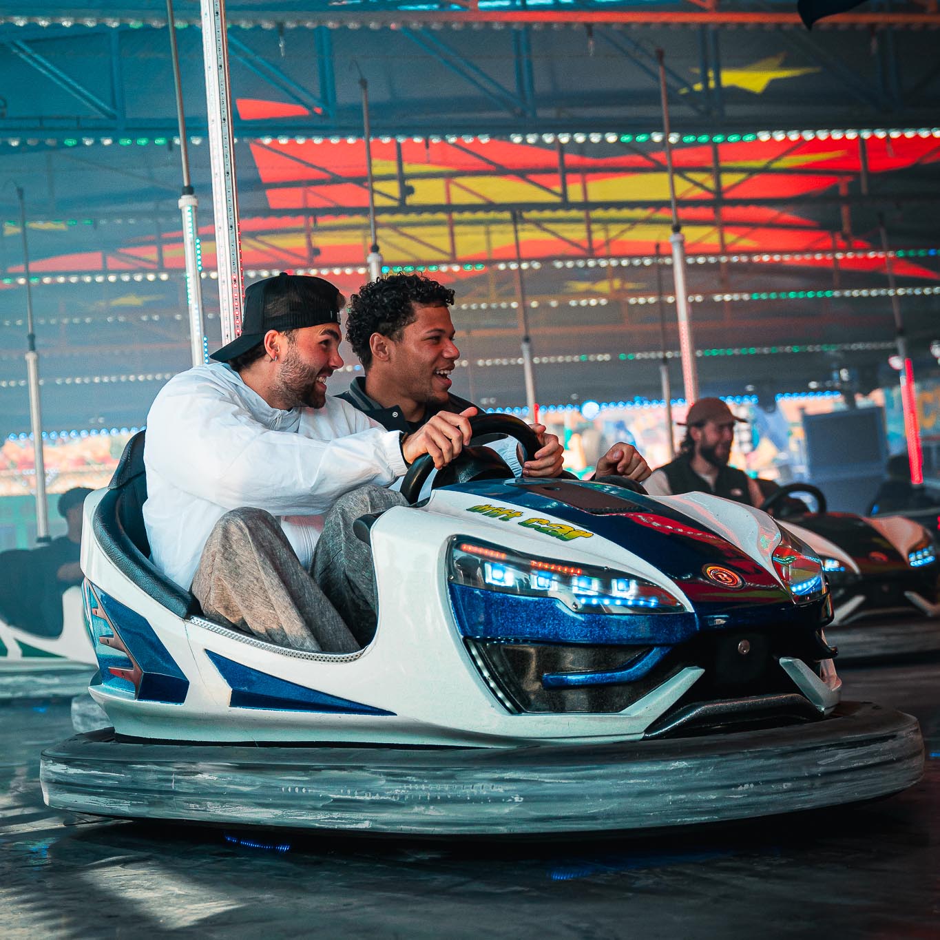 Kolja Oudenne und Montell Ndikom fahren Autoscooter.