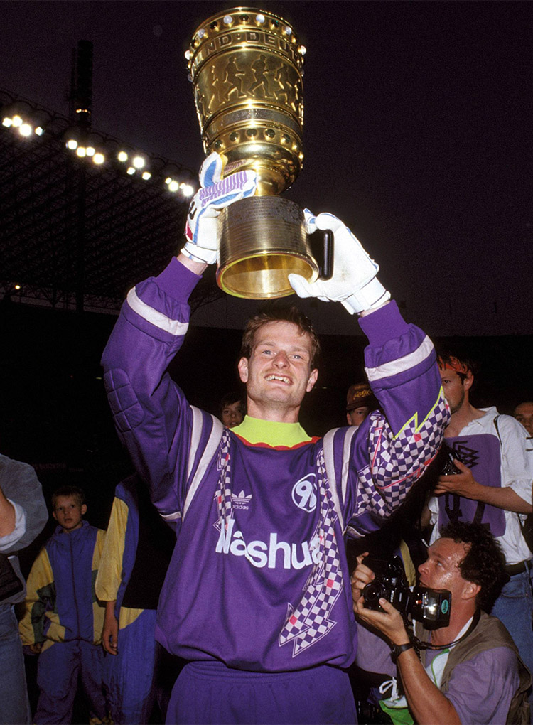 Jörg Sievers reckt strahlend den DFB-Pokal in die Höhe.