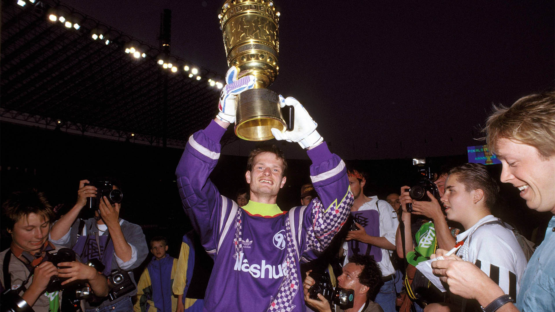 Jörg Sievers reckt strahlend den DFB-Pokal in die Höhe.