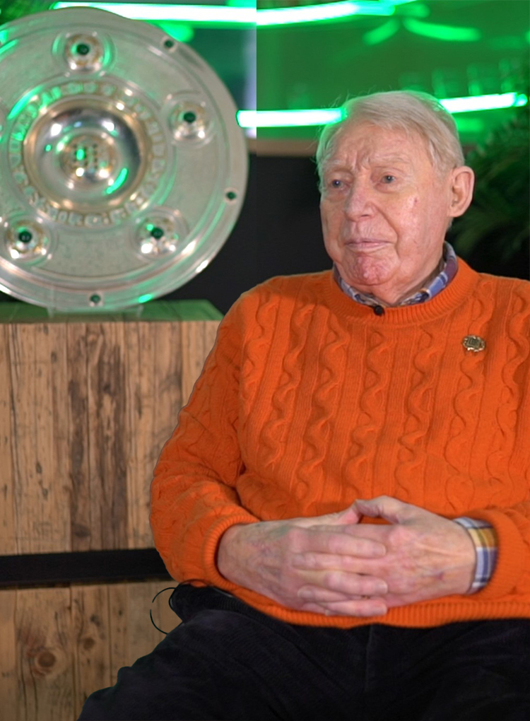 Rolf Gehrcke sitzt neben der Meisterschale.