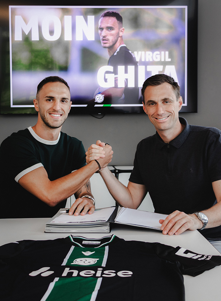 Hannover-96-Neuzugang Virgil Ghita beim Handshake mit 96-Geschäftsführer Marcus Mann in dessen Büro.