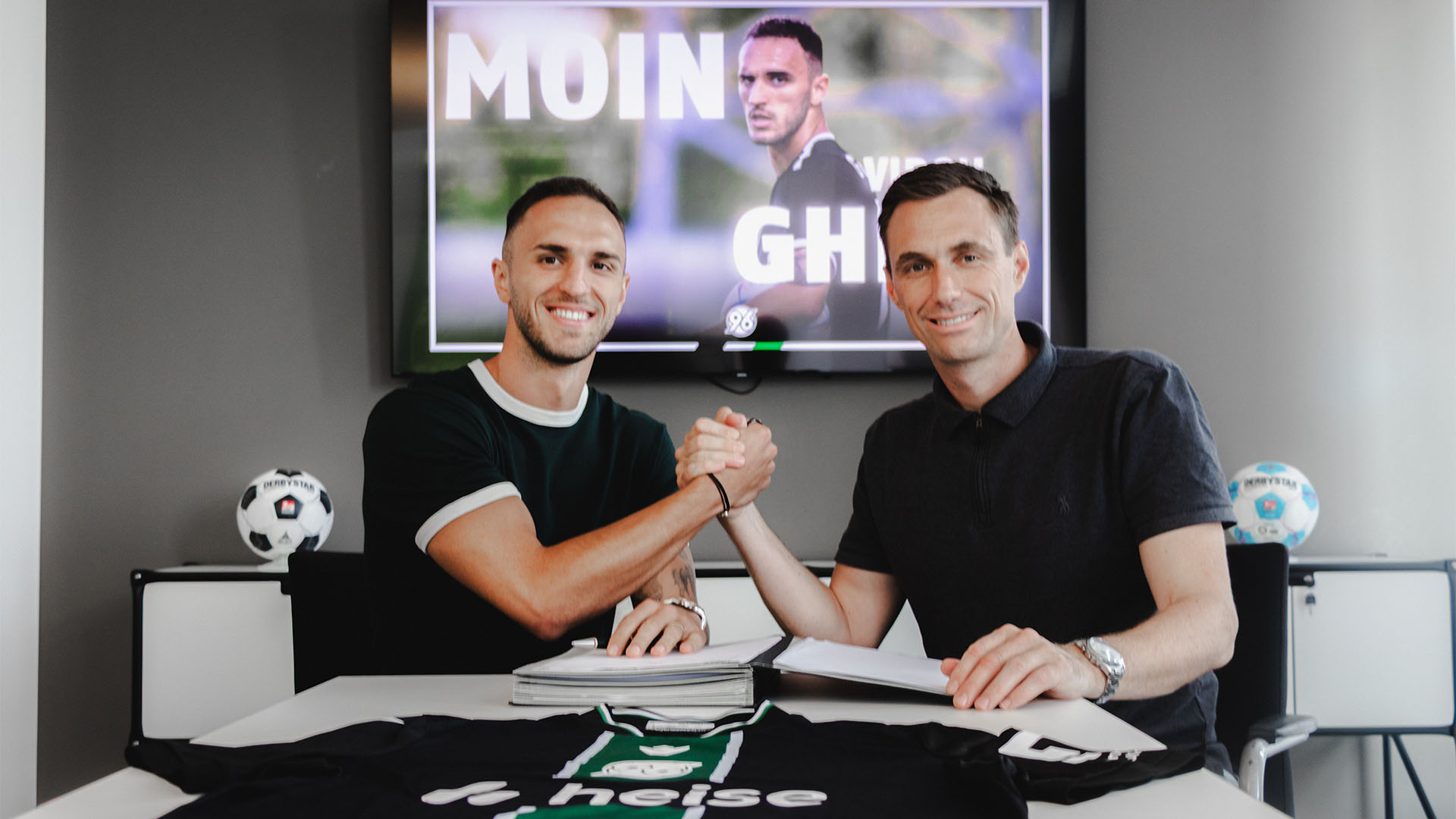 Hannover-96-Neuzugang Virgil Ghita beim Handshake mit 96-Geschäftsführer Marcus Mann in dessen Büro.