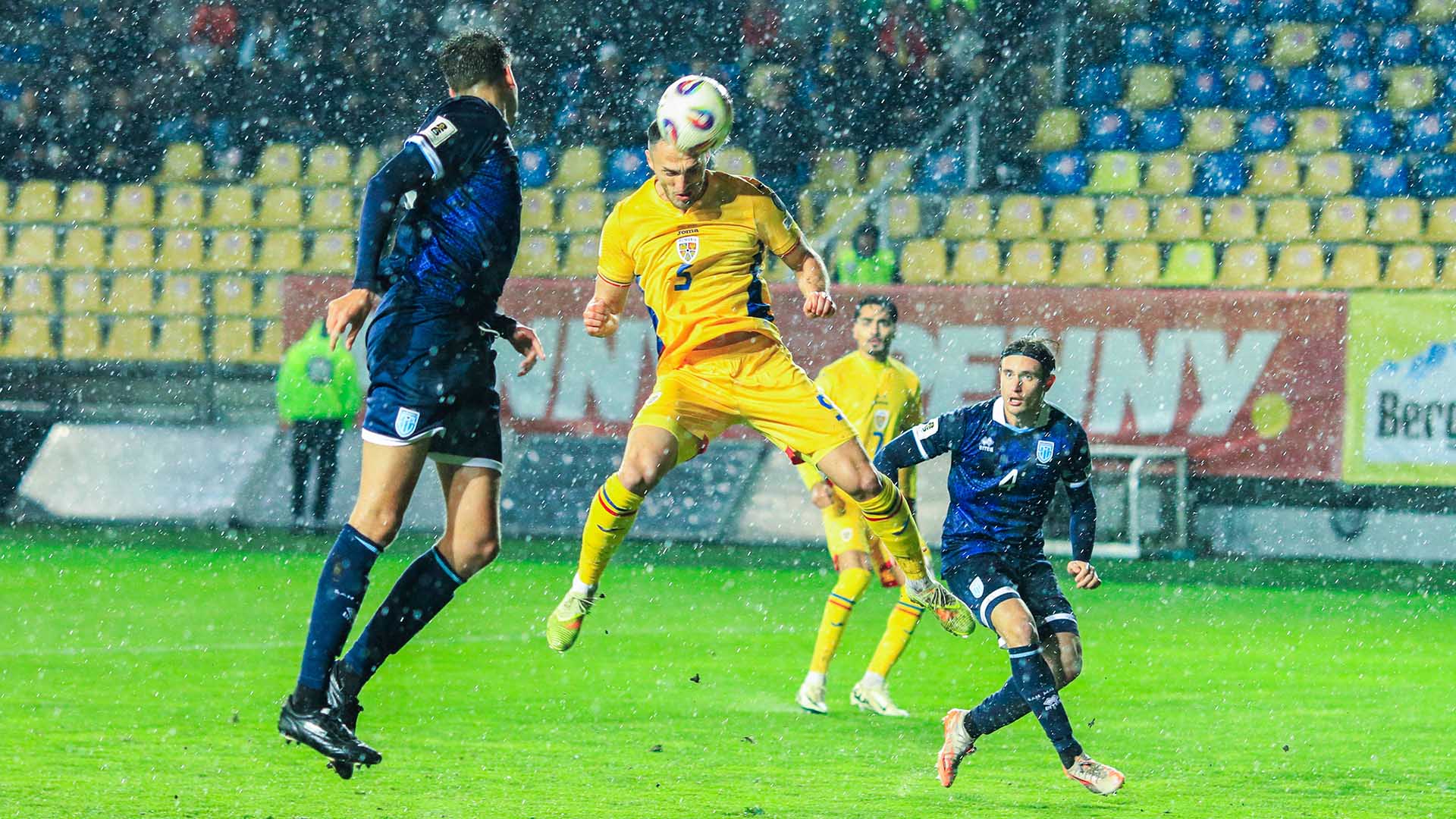 Virgil Ghita trägt das gelbe Rumänien-Trikot im Spiel gegen San Marino und führt in der Luft einen Kopfball aus.