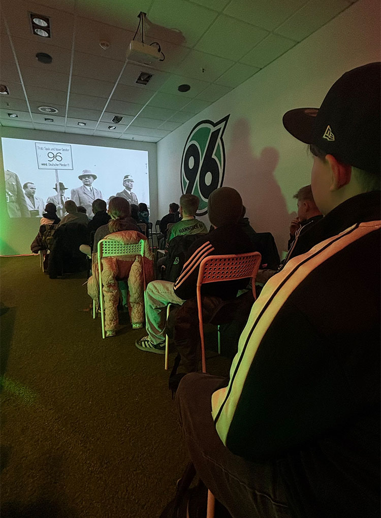 Die Kinder schauen einen Film auf einer Leinwand.