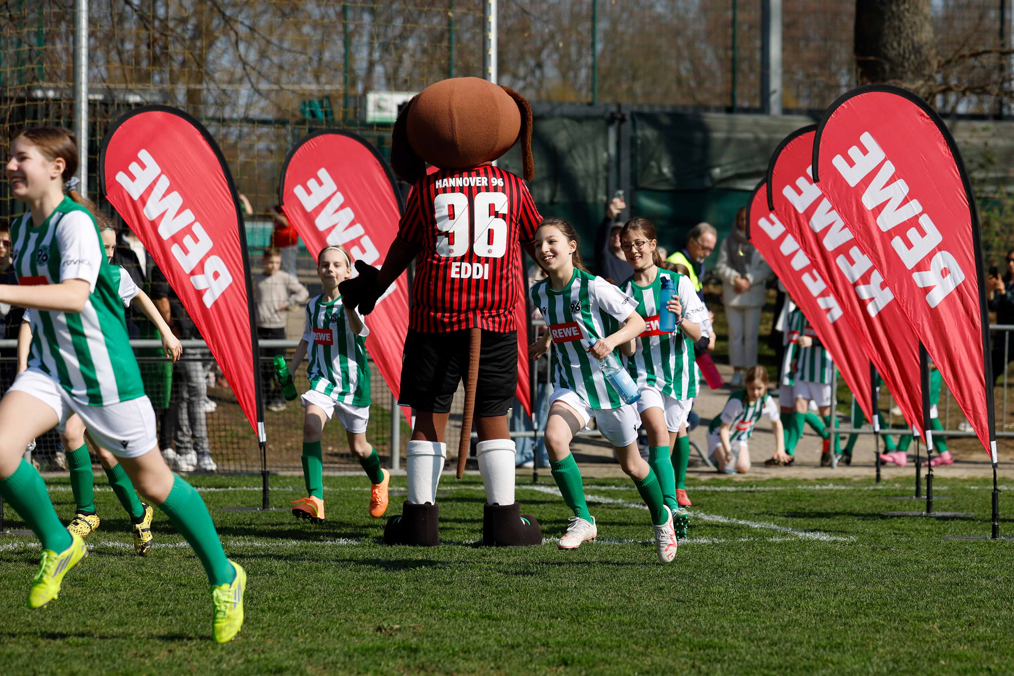 Die Kids laufen gemeinsam auf den Rasen.