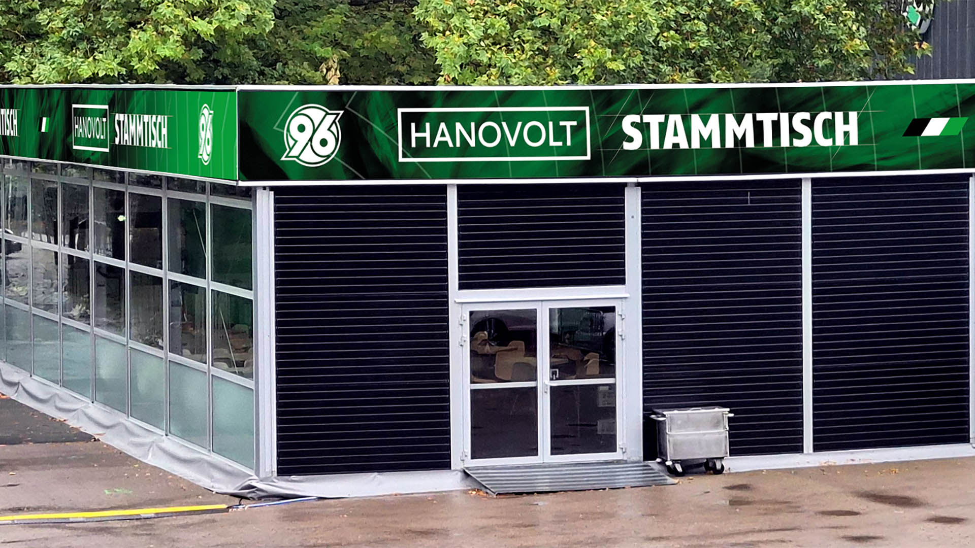 Blick auf einen großen Pavillon vor dem Stadion mit der Aufschrift HANOVOLT-Stammtisch.