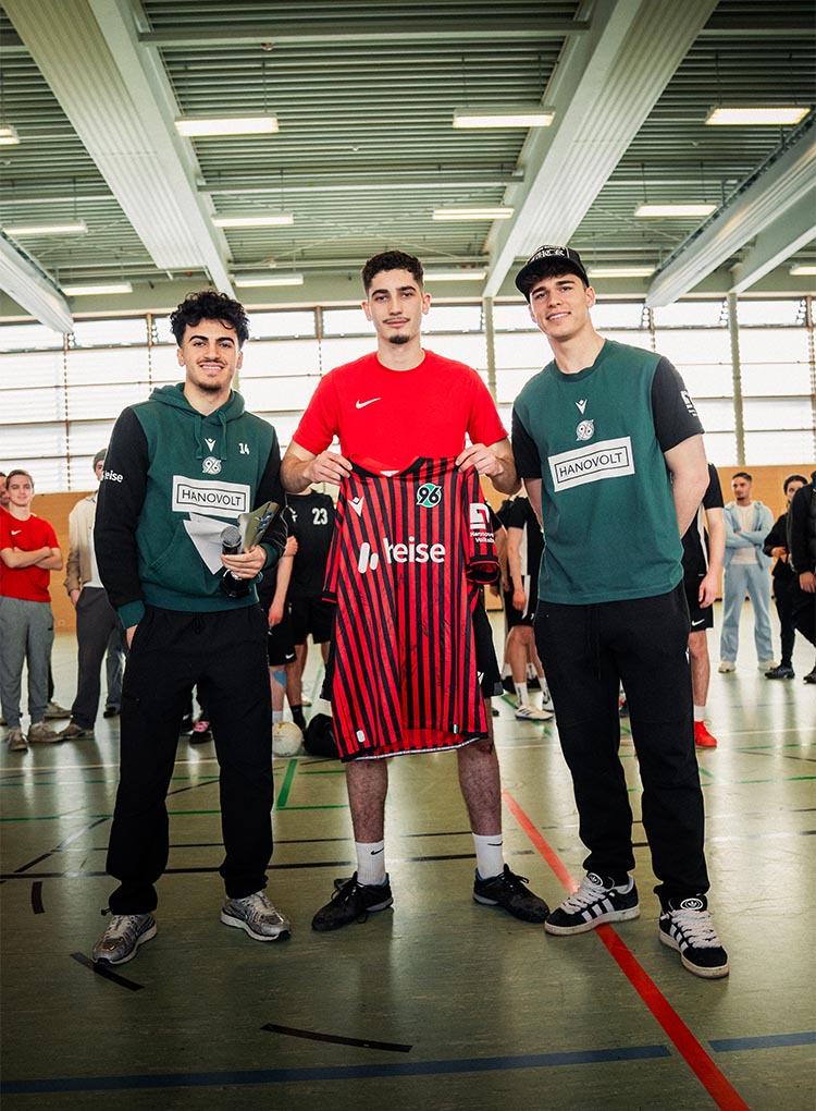 Chakroun und Weißhaupt mit einem Gewinner, der ein unterschriebenes 96-Trikot hält.