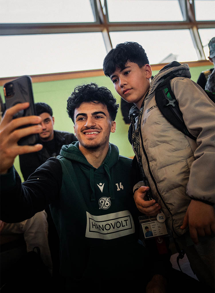 Husseyn Chakroun macht ein Foto mit einem Jungen.