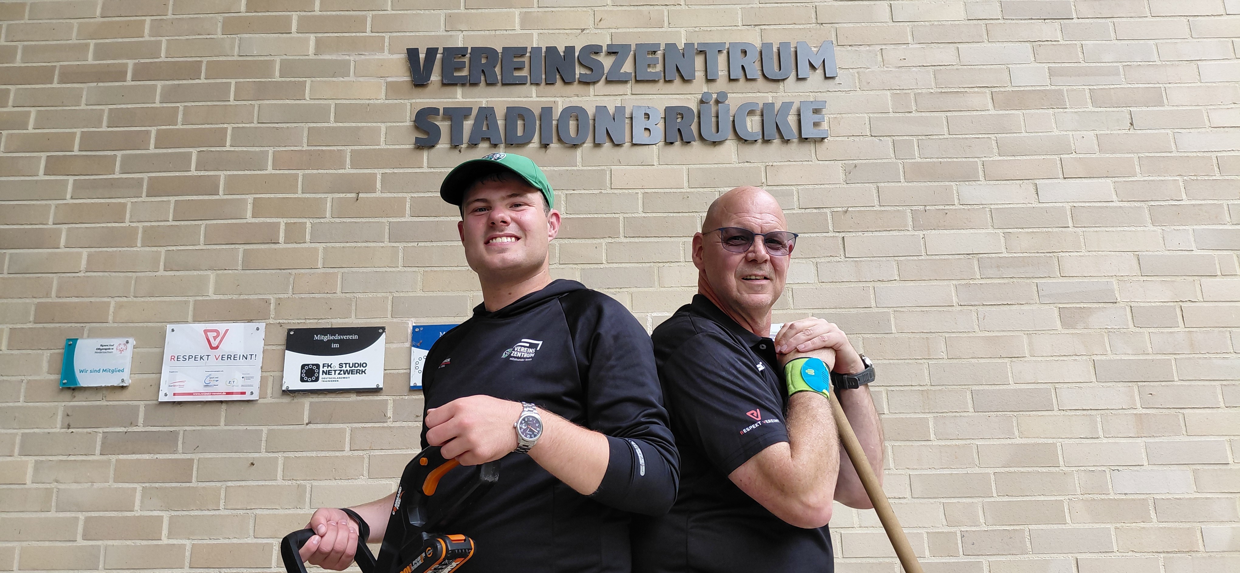 Tim Sander und Thorsten Scheidler lächeln mit Werkzeug in die Kamera.