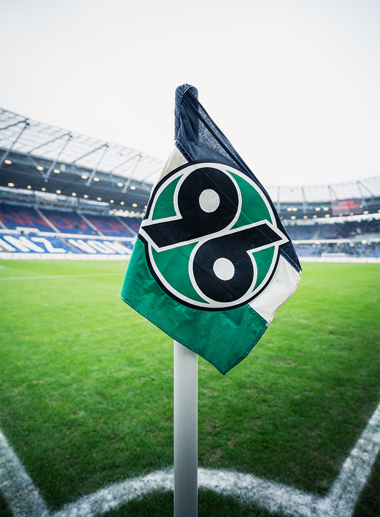 Die 96-Eckfahne im Stadion, im Hintergrund unscharf das Stadion.