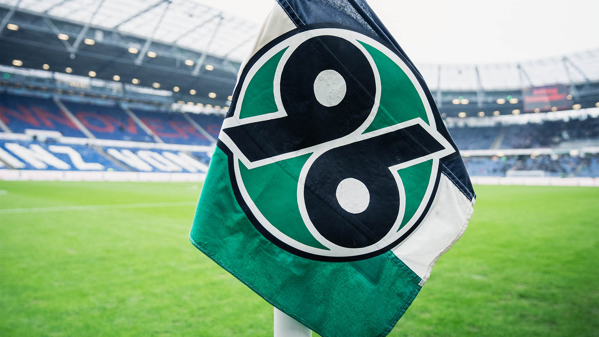 Die 96-Eckfahne im Stadion, im Hintergrund unscharf das Stadion.
