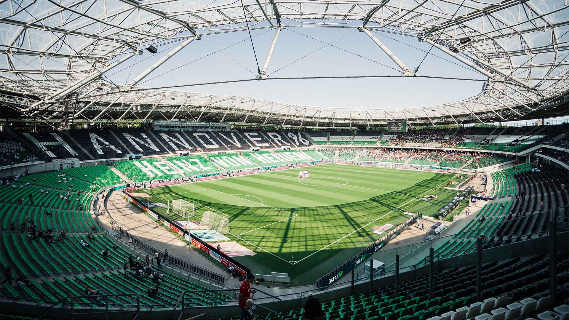 Blick ins 96-Stadion bei Sonne, im Norden sind bereits einige Fans auf den Rängen, in den anderen Bereichen nur vereinzelt. 