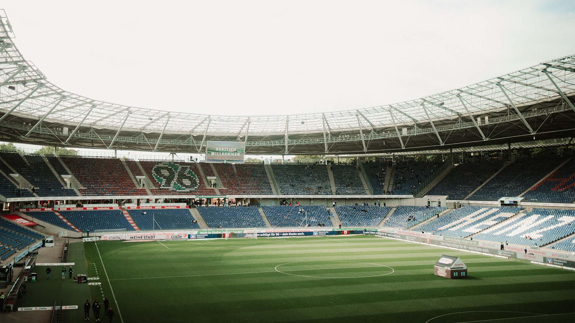 Blick in die leere Heinz von Heiden Arena, auf der Videowall steht "Herzlich willkommen". 