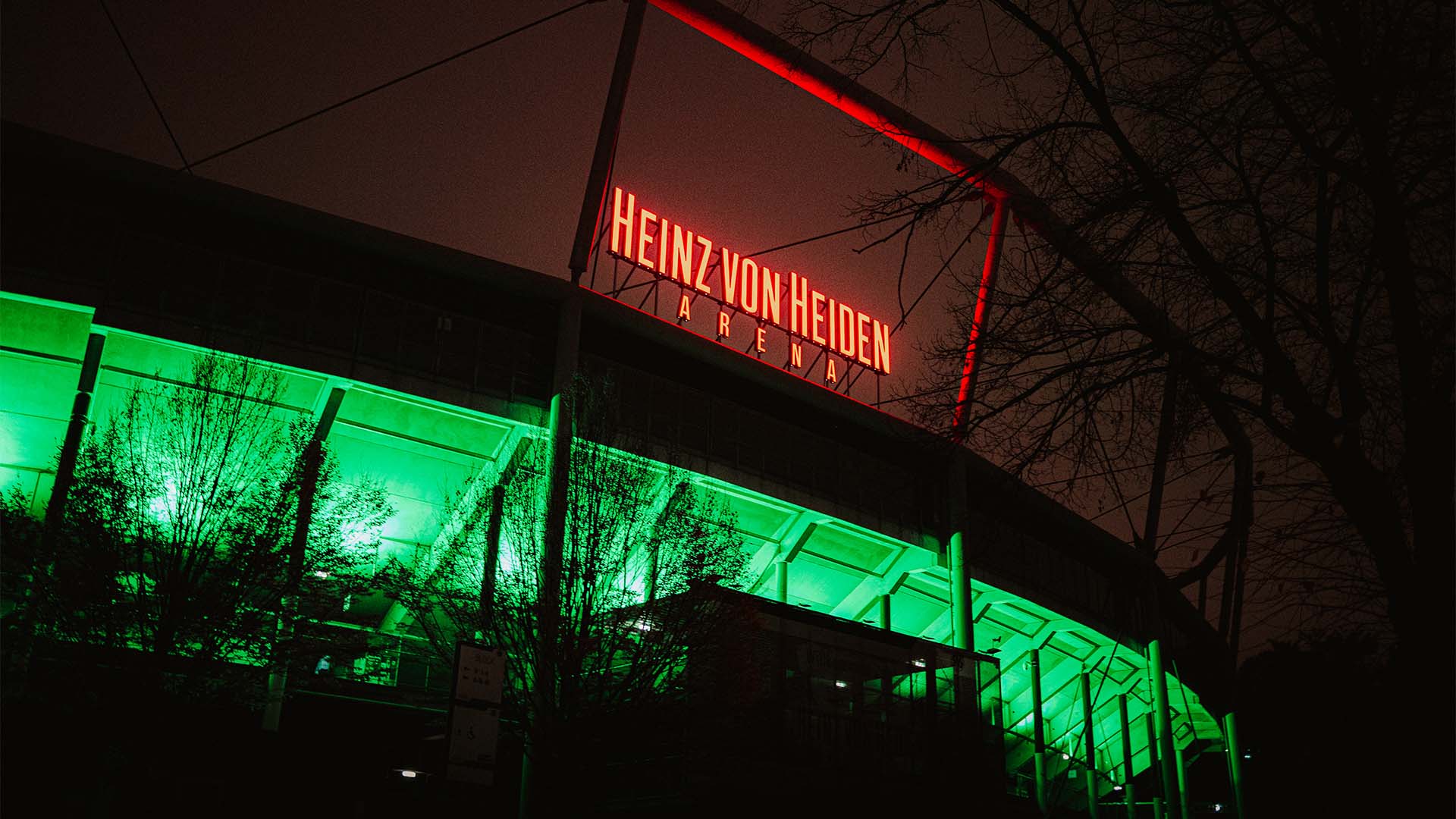 Blick auf den erleuchteten Heinz-von-Heiden-Arena-Schriftzug im Dunkeln.