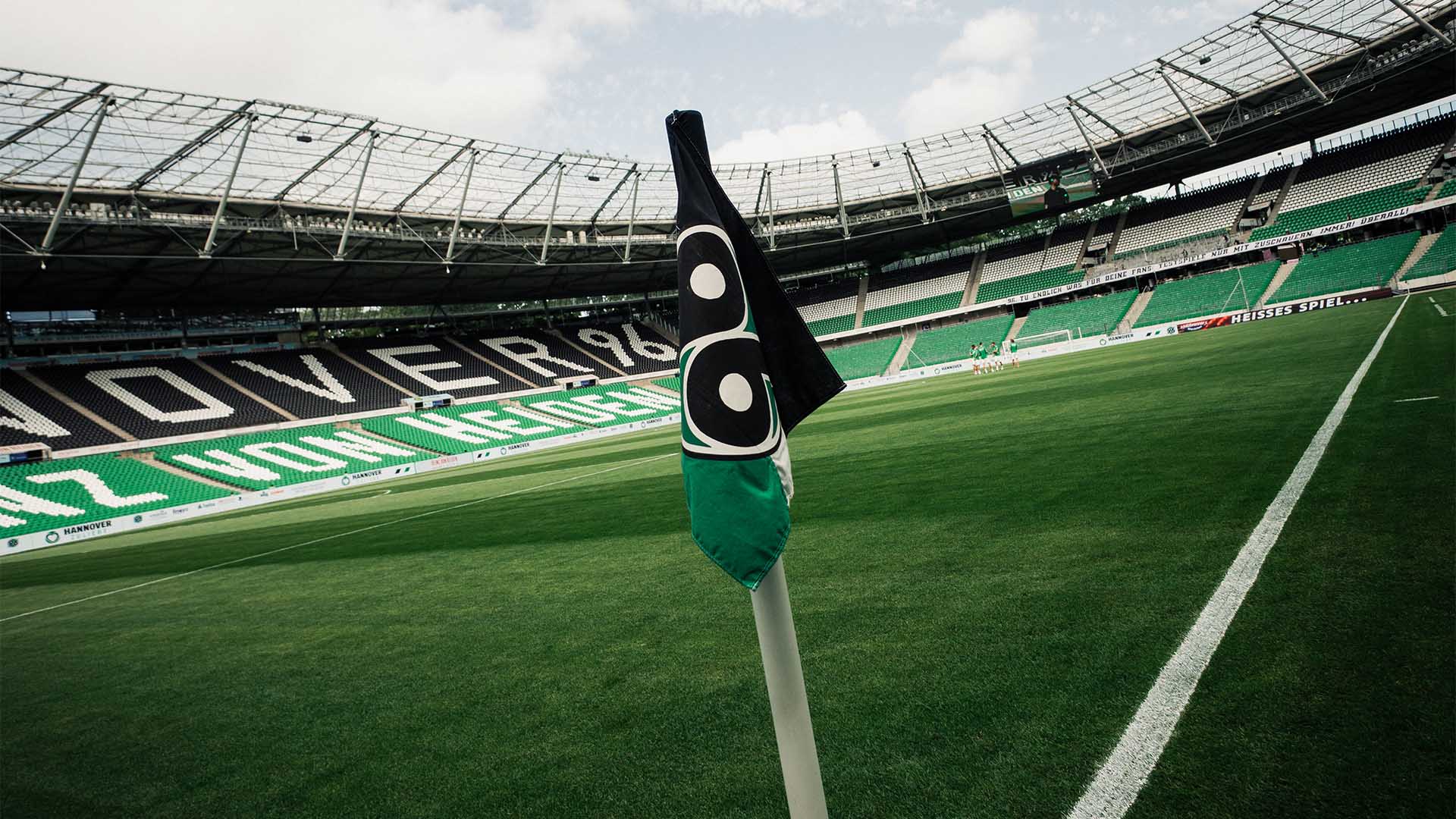 Blick ins leere, schwarz-weiß-grüne 96-Stadion mit der 96-Eckfahne im Vordergrund.