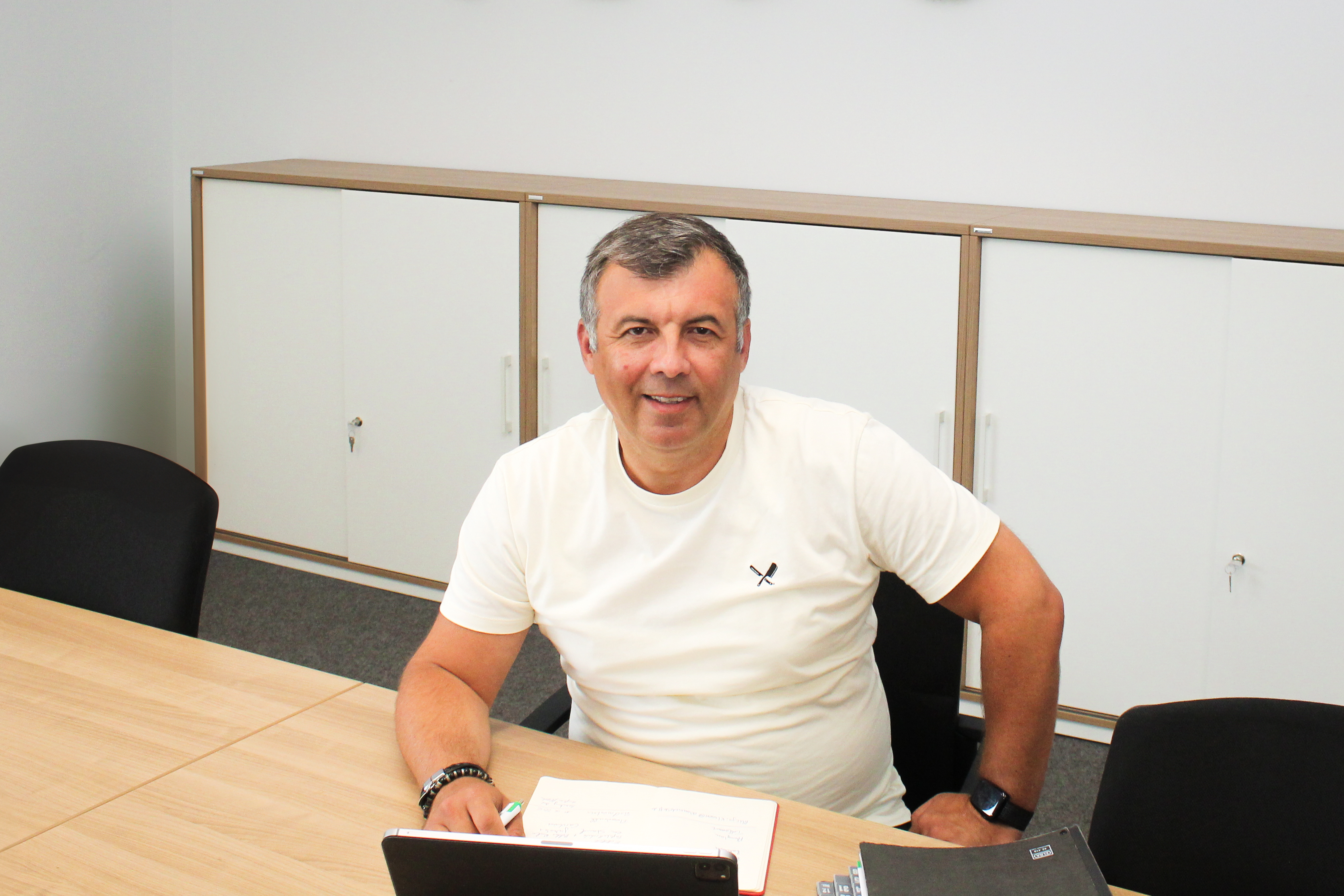 Hakan Alhan sitzt im Besprechungsraum des Vereinszentrums und gibt ein Interview